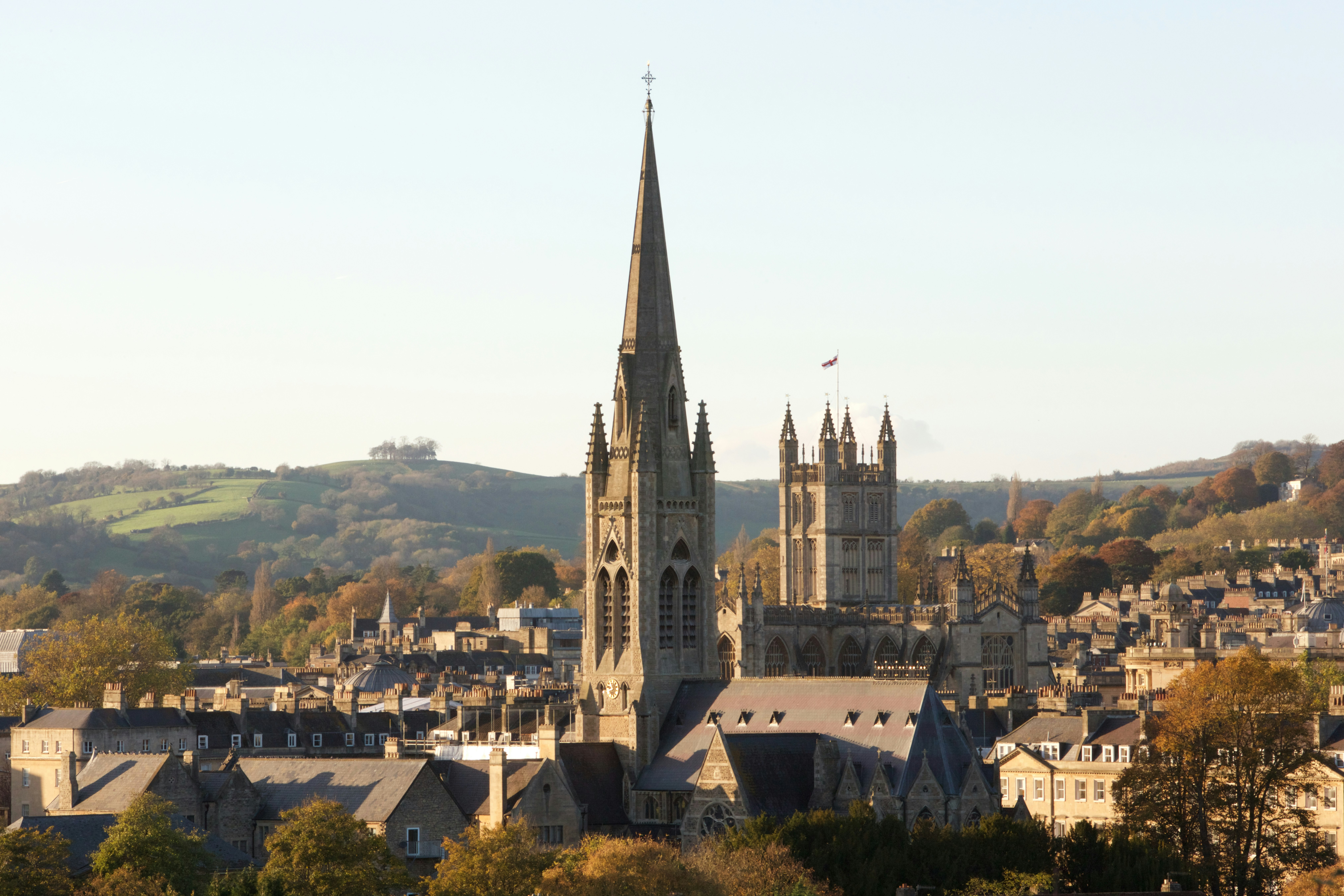 The skyline of Bath, England. A large church juts out from a cluster of Georgian-style buildings. 