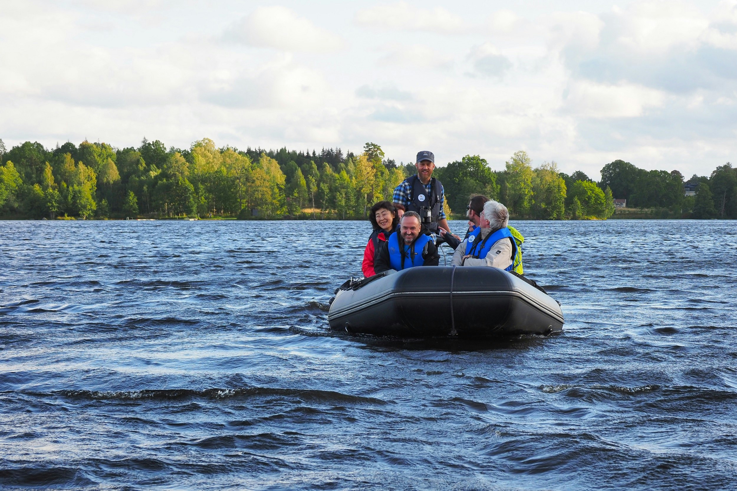 An RIB (rigid inflatable boat) with an electric engine tours a lake with several guests