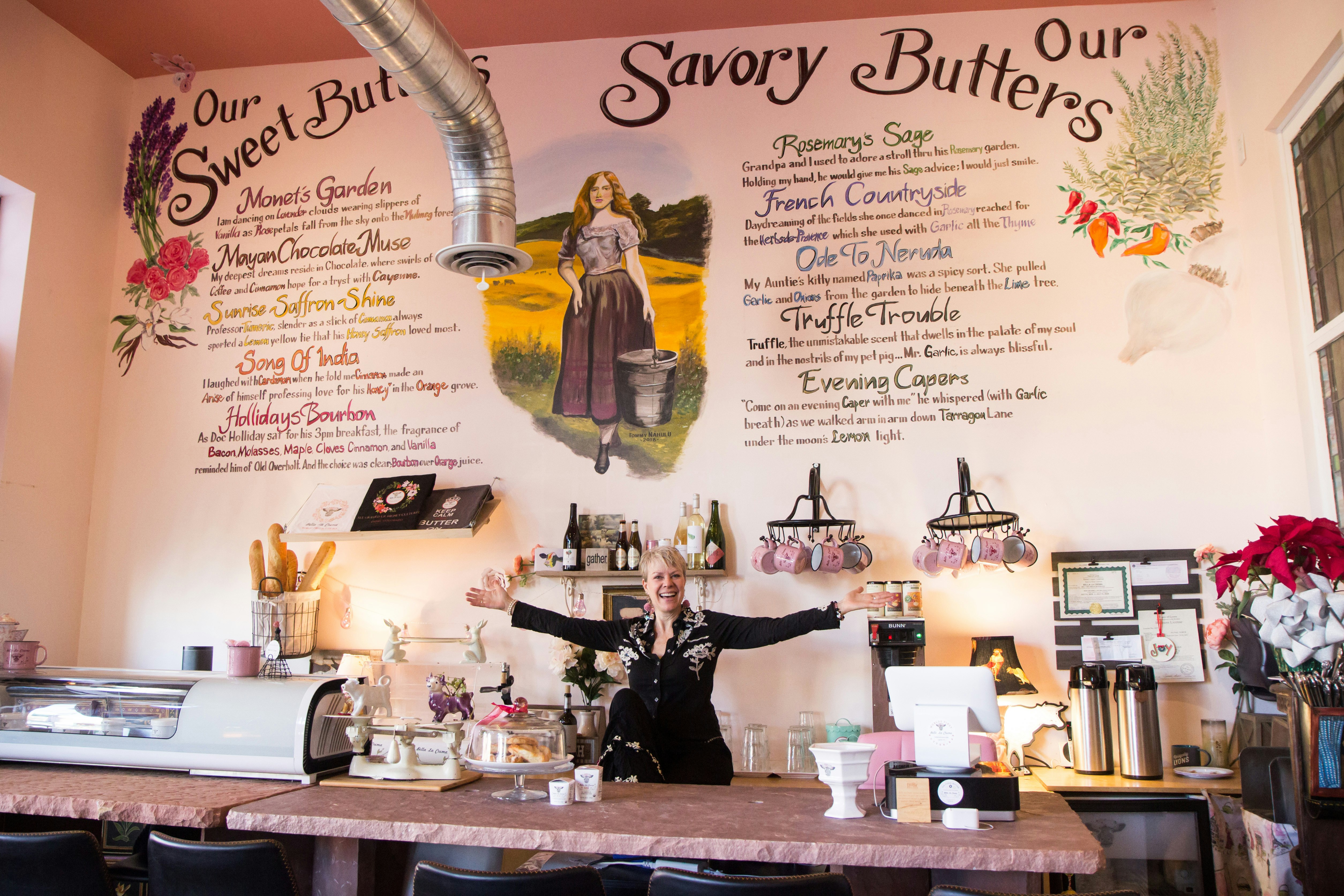 The owner of Bella la Crema in front of her menu of sweet and savory butters