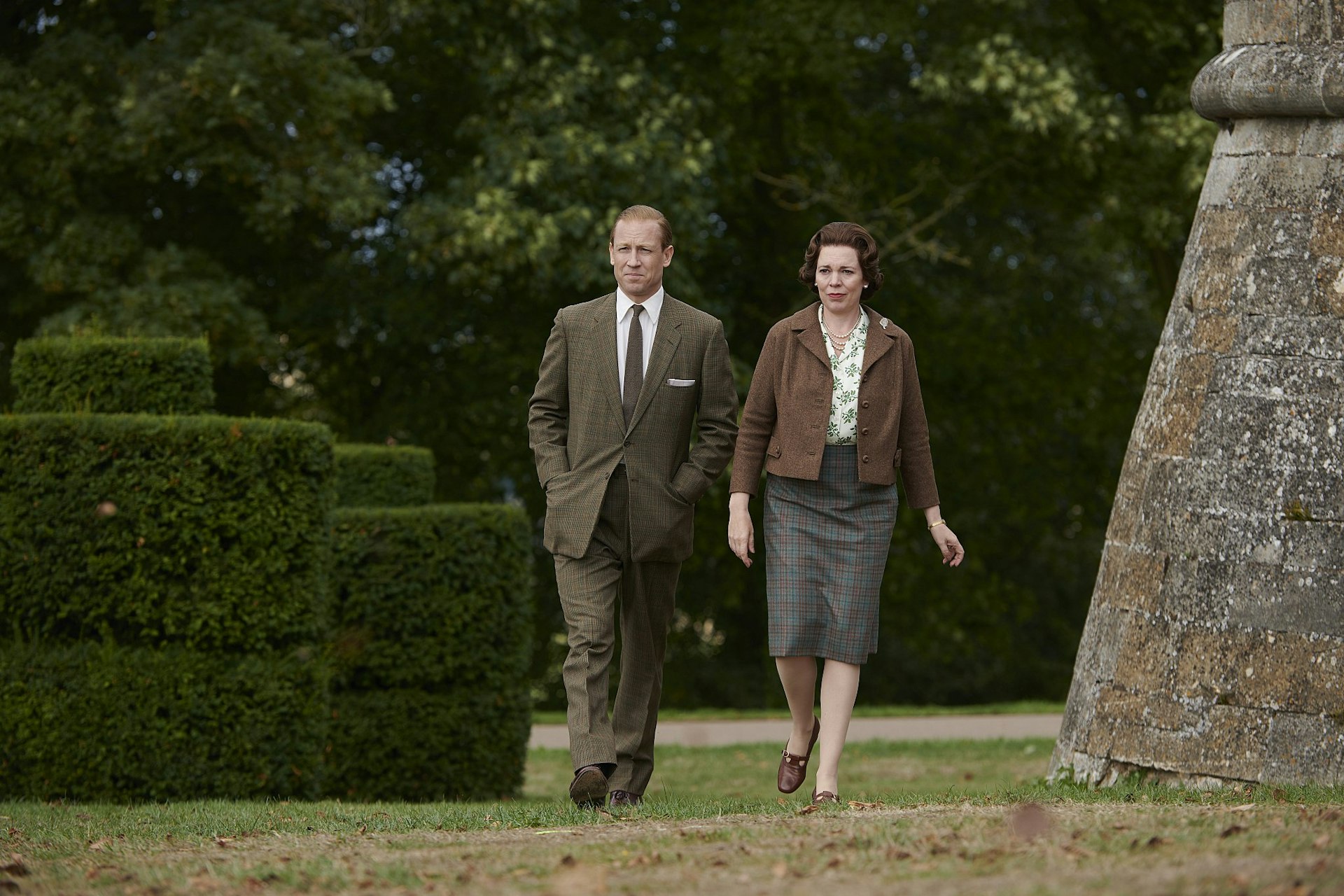 A still from The Crown season 3; it shows the Queen (Olivia Colman) and Prince Philip (Tobias Menzies) walking in the grounds of Belvoir Castle.