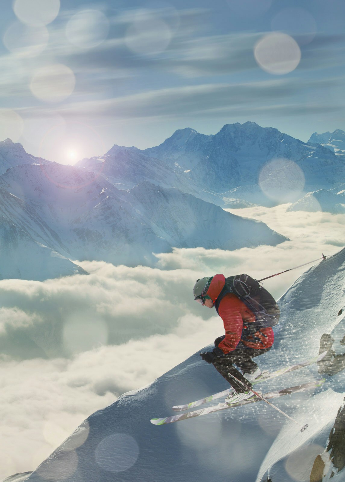 An extreme skier jumping on a snowy slope with a cloud-filled valley below