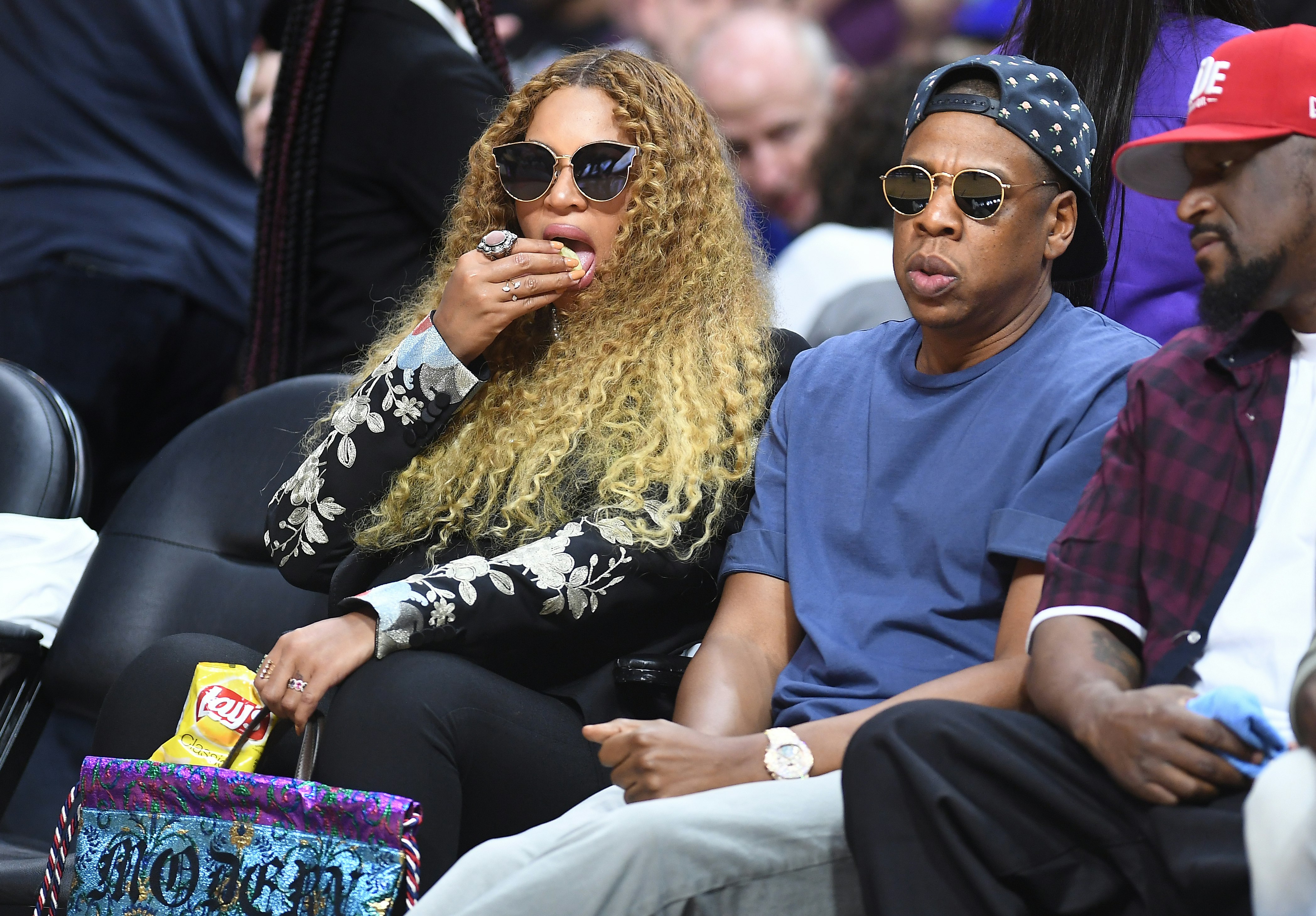 Beyonce eating snacks, sitting courtside with Jay Z at an NBA game