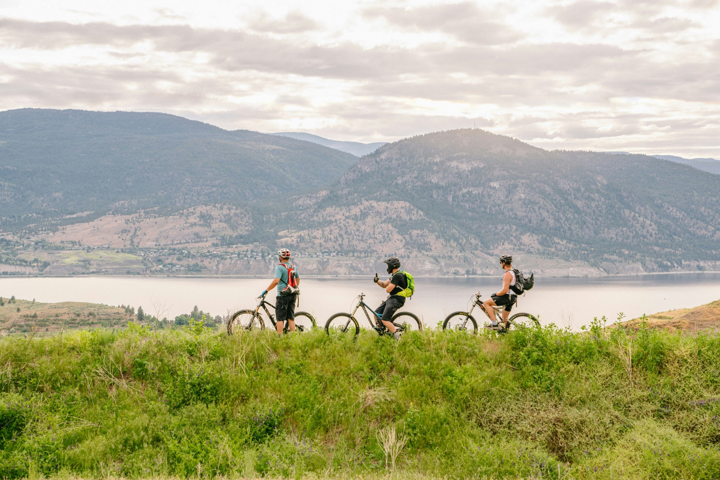 People stand by their bicycles by a lakeside in British Columbia