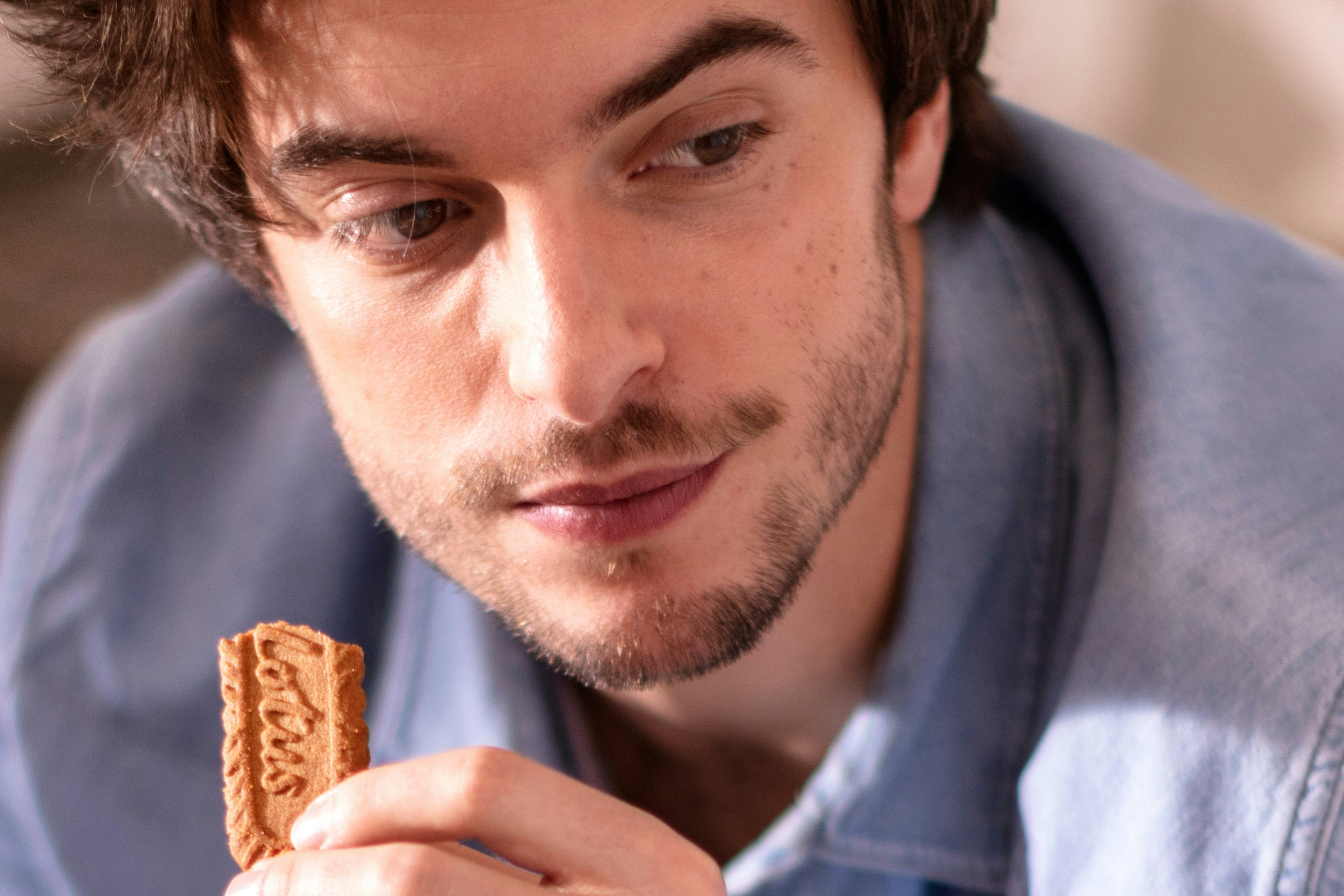 A man eating a Biscoff cookie