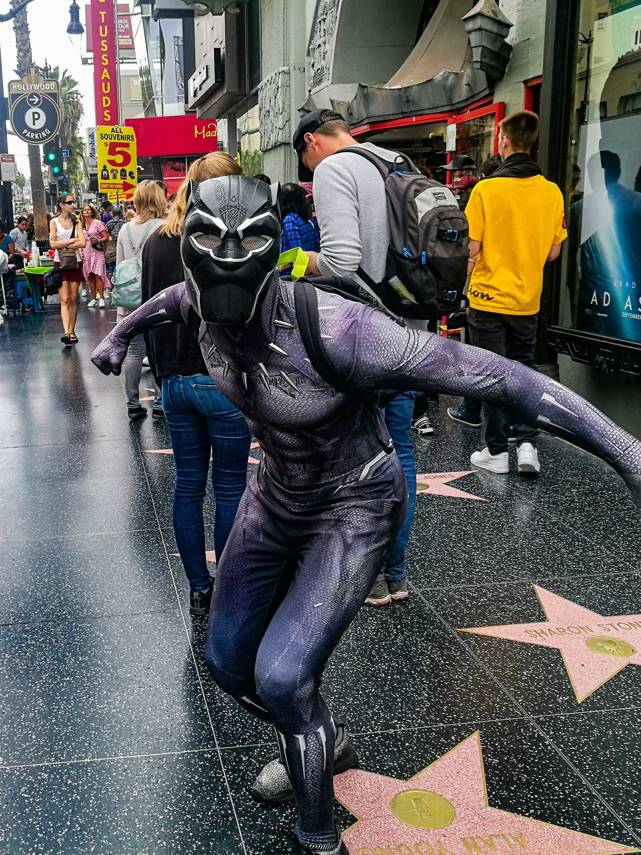 Black Panther stands on the Hollywood Walk of Fame, with people in the background