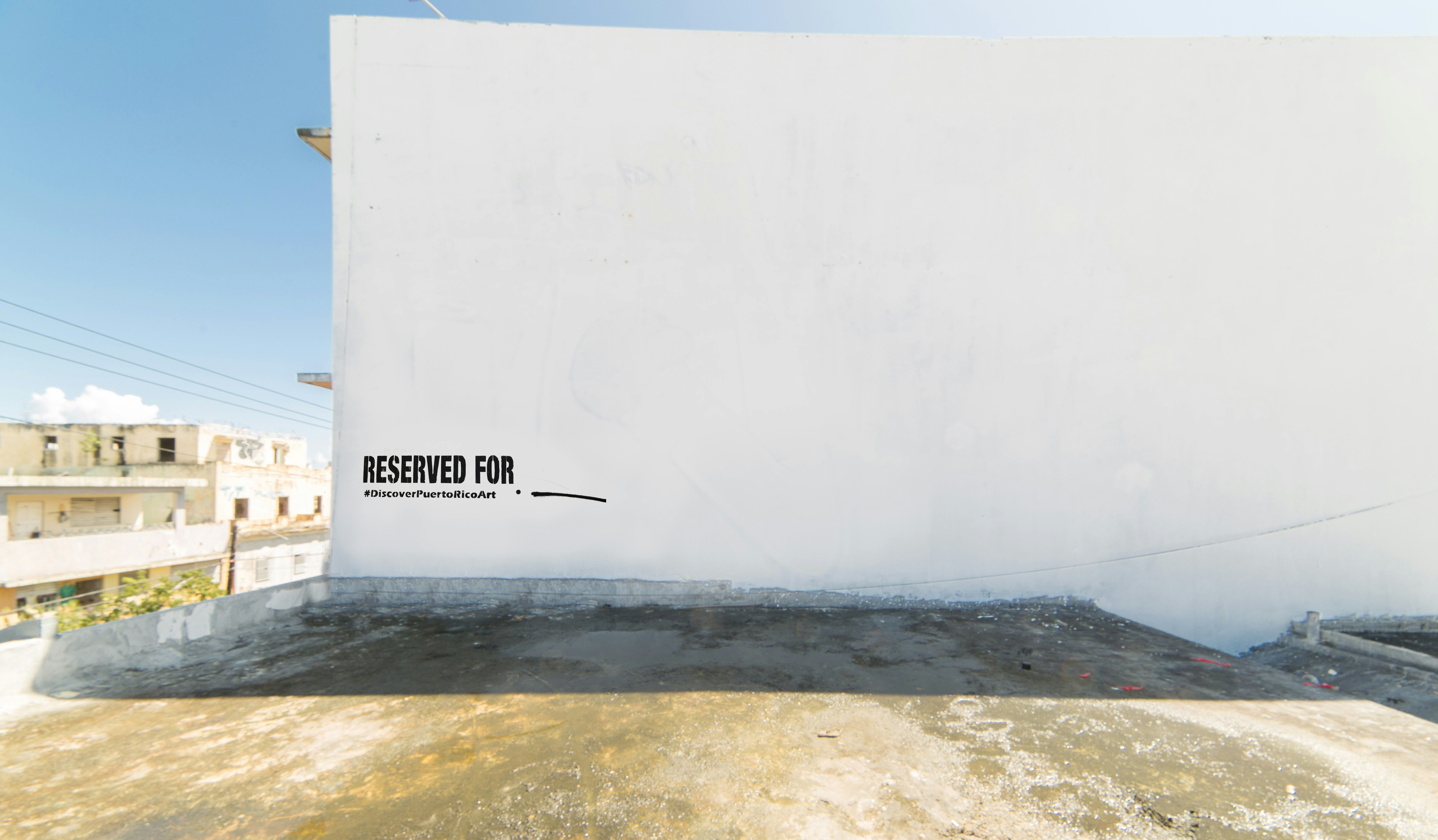 A blank white wall on a street in Puerto Rico