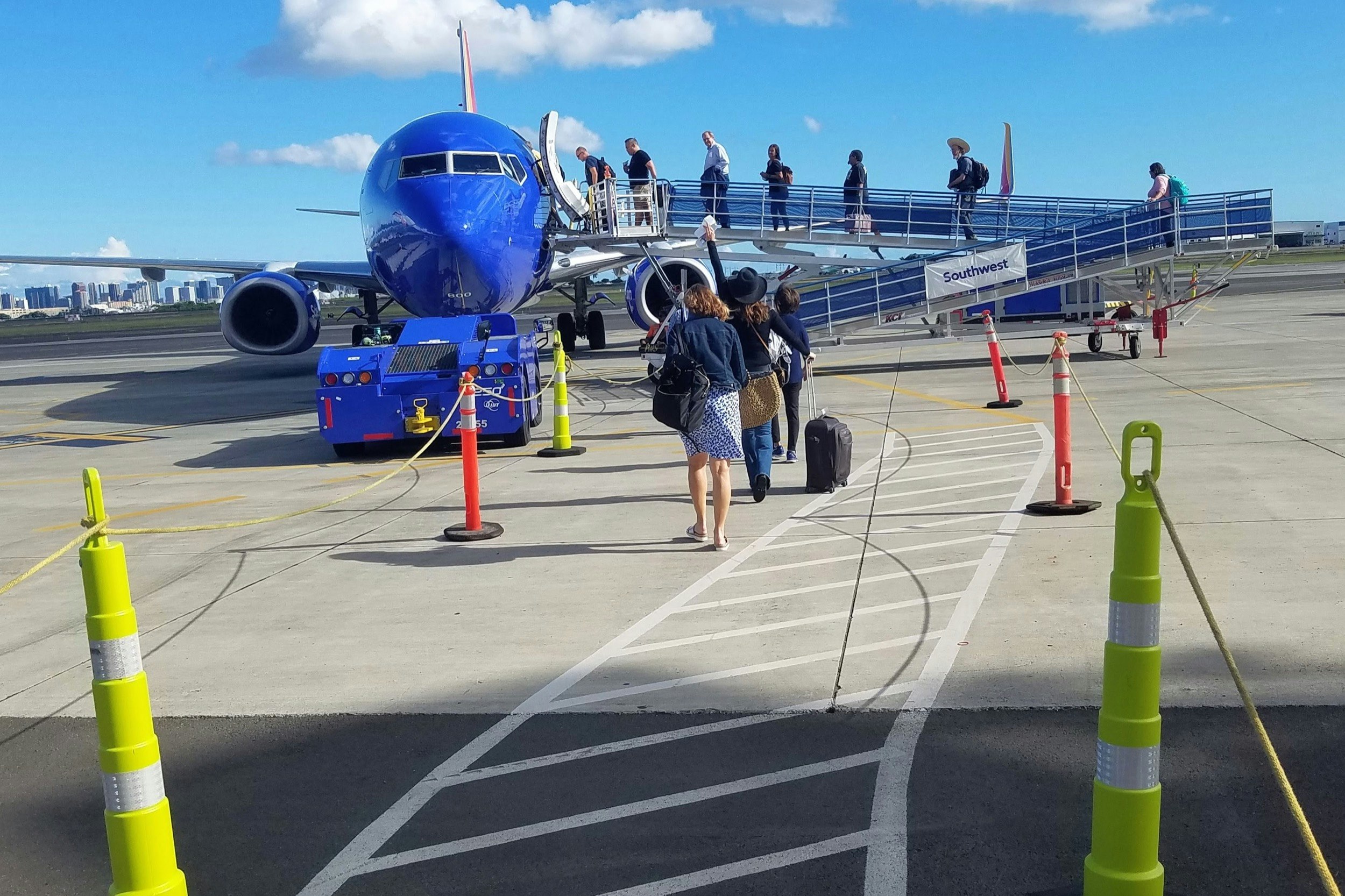 Using old-fashioned ramps that are exposed to the elements, passengers board a Southwest Airlines flight in a remote area of Honolulu’s Inouye International Airport. 