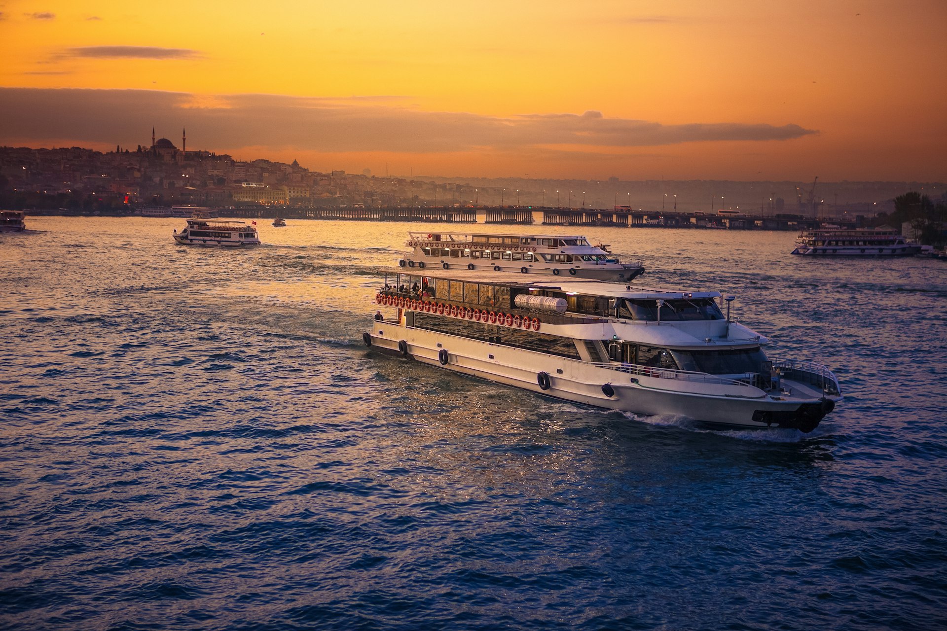 Boats motor along the Bosphorus in Turkey with the Istanbul skyline in the background