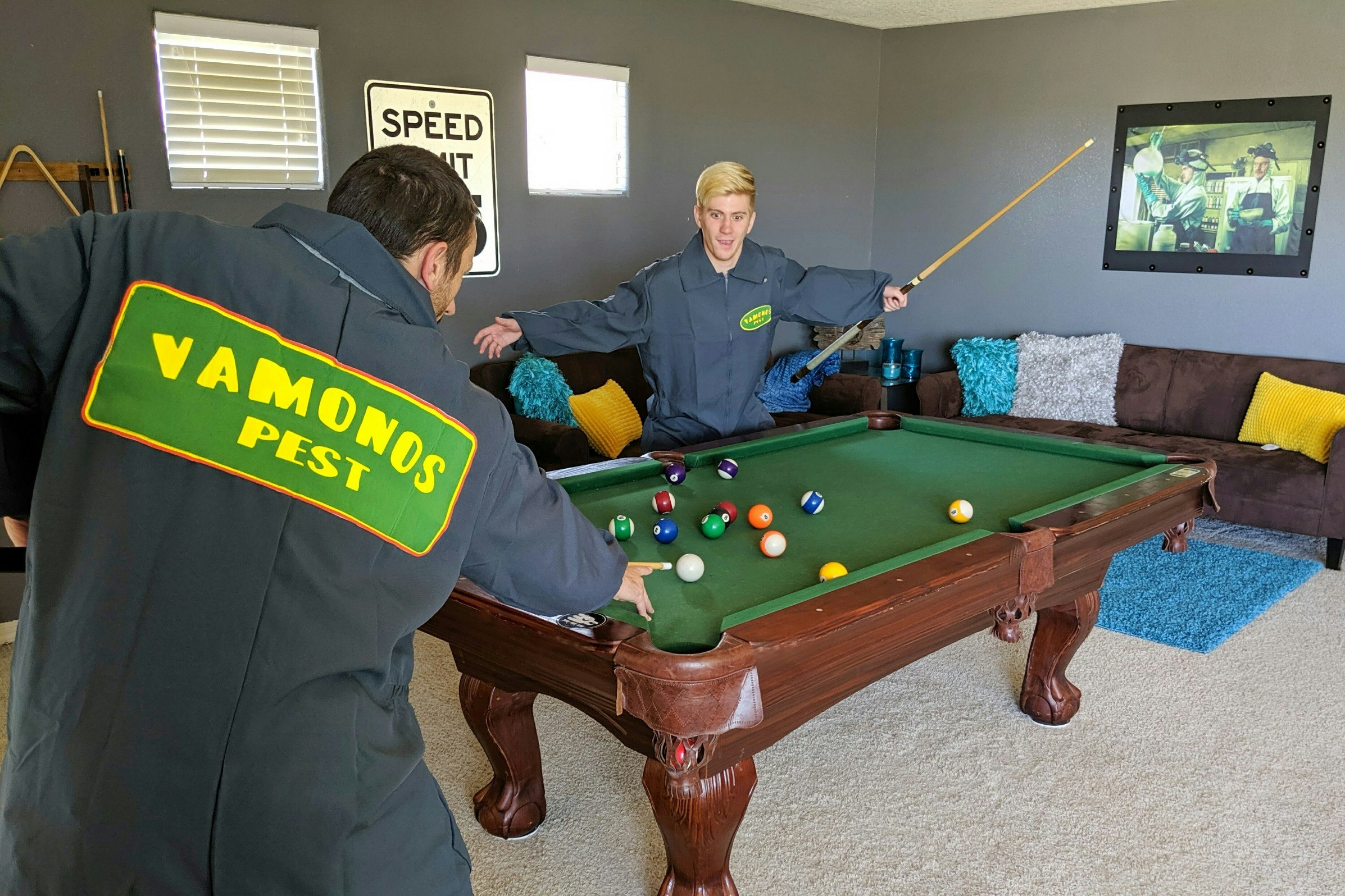 Guests playing pool and wearing Vamanos Pest uniforms