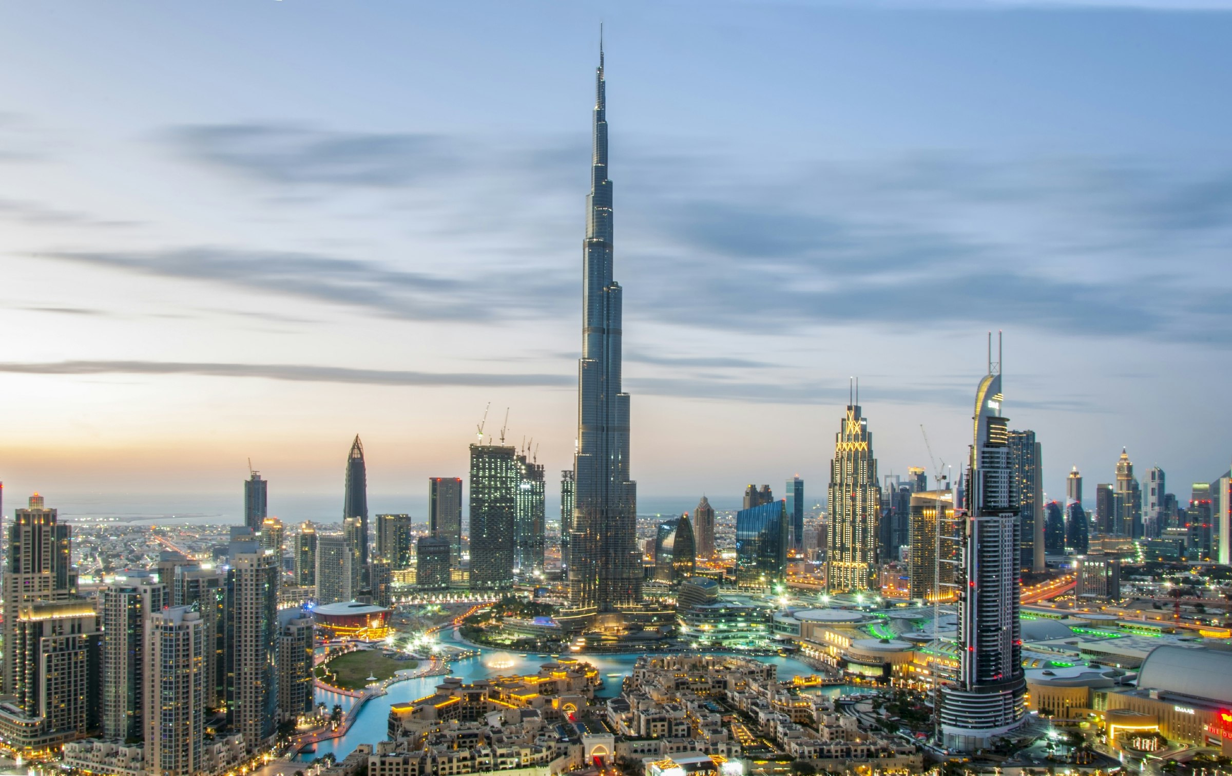A Dubai Downtown cityscape at sunset, with Burj Khalifa and busy roads in the foreground