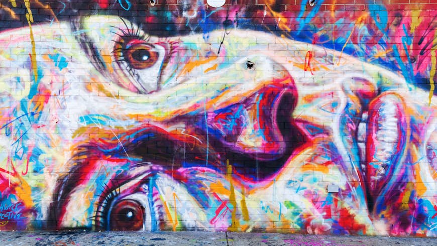 A colorful graffiti image of a woman with her eyes looking to the sky painted on a wall in New York City.