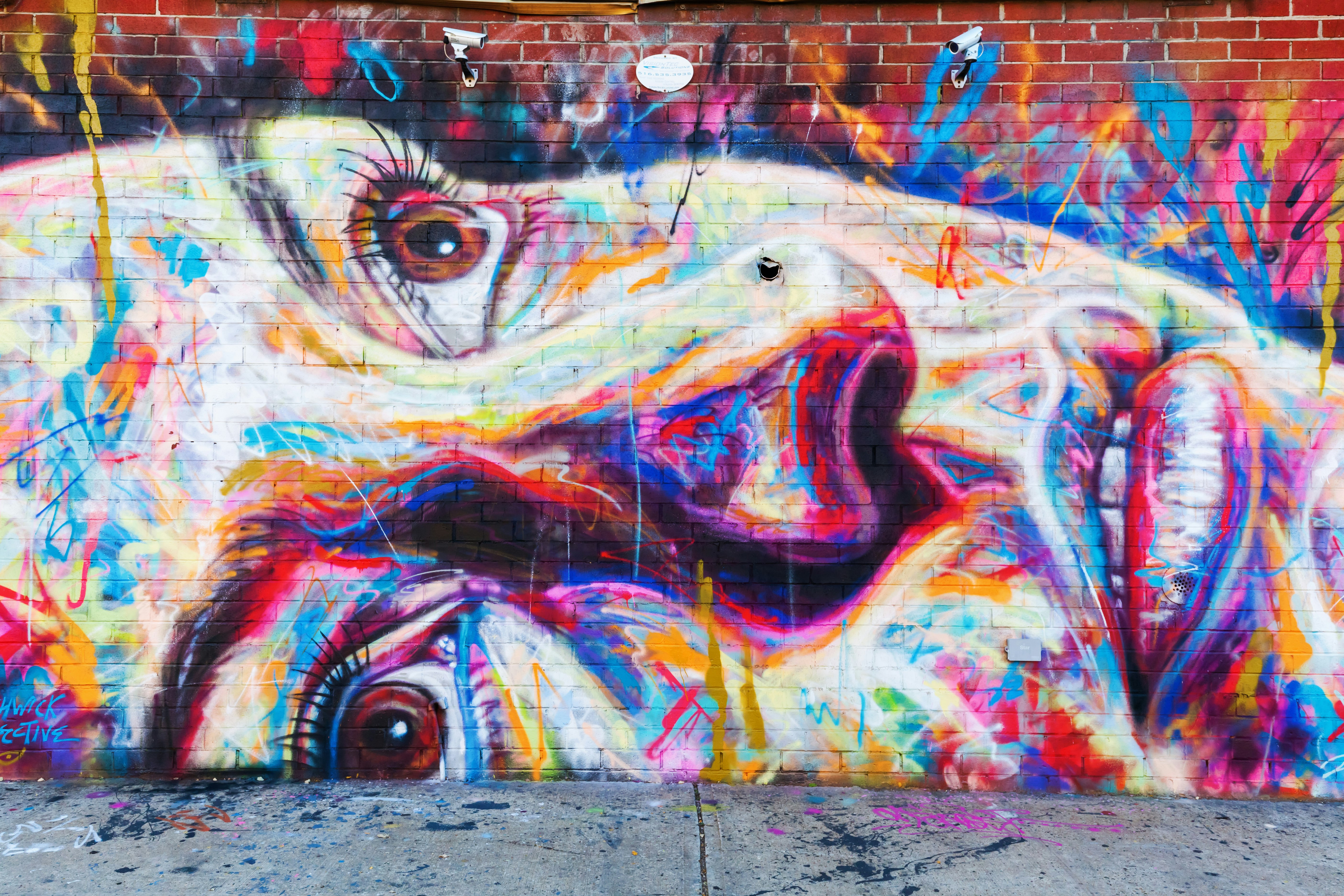A colorful graffiti image of a woman with her eyes looking to the sky painted on a wall in New York City.