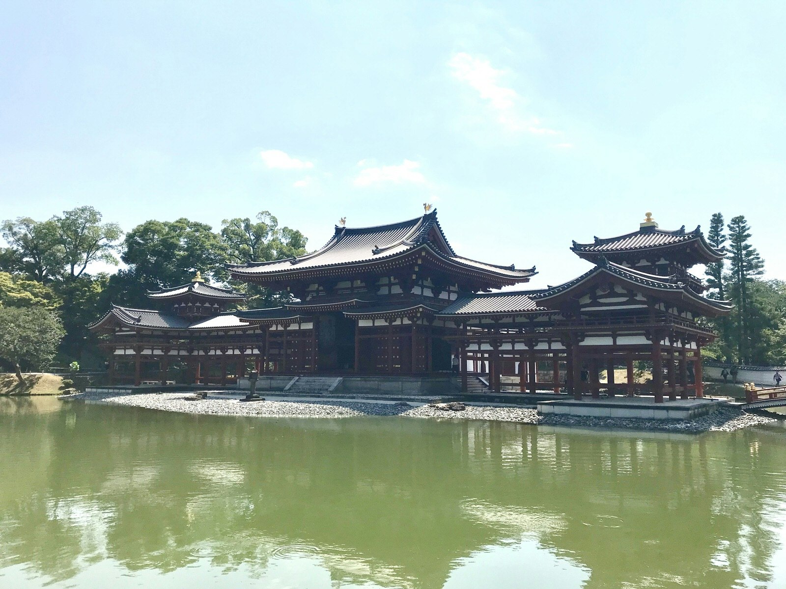Byōdō-in temple in Uji, viewed from across a still body of water on a clear day. 