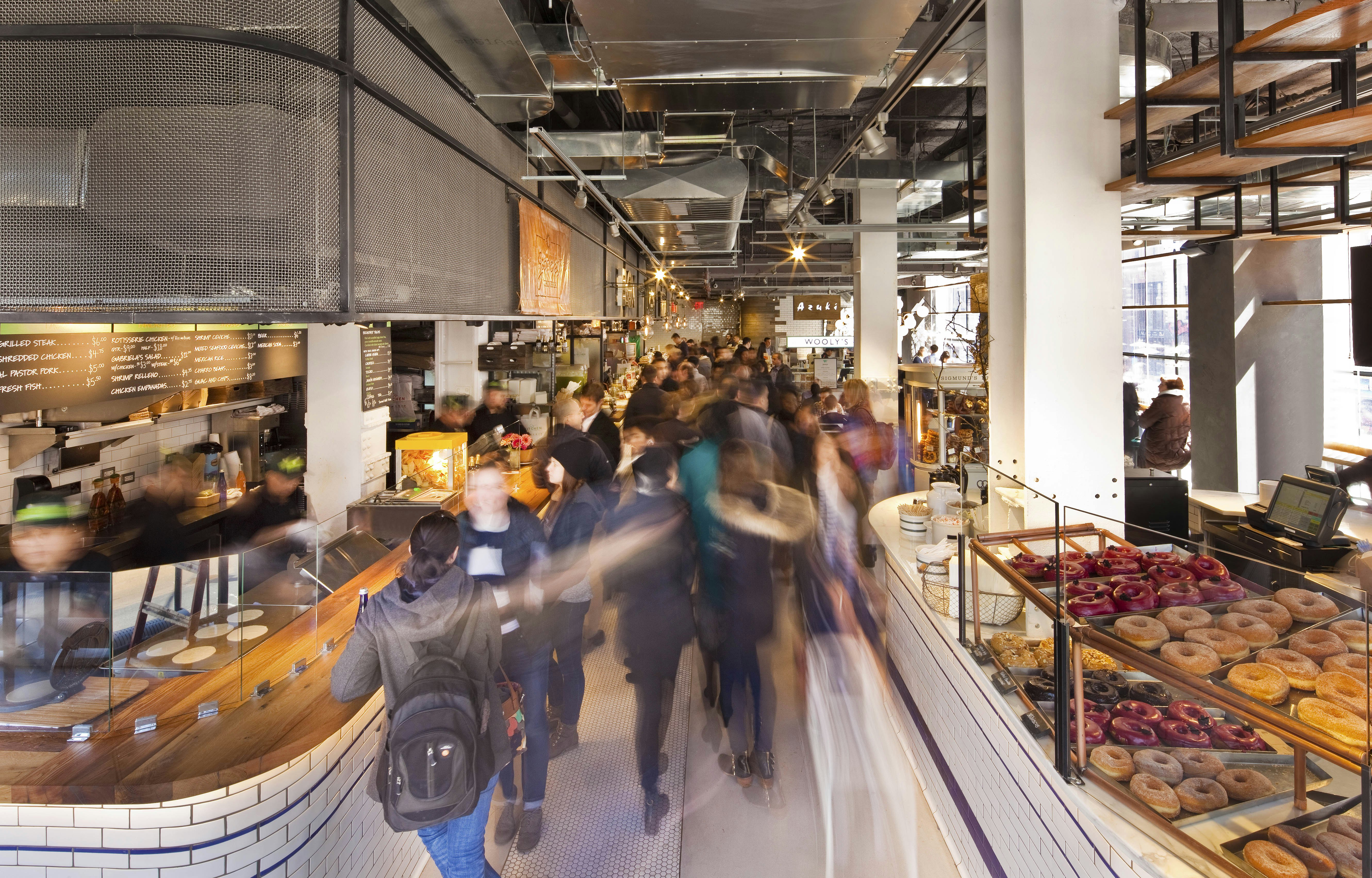 Long exposure shot of the interior of City Kitchen food hall. The delicious food on display can be seen clearly, while the patrons are a blur.