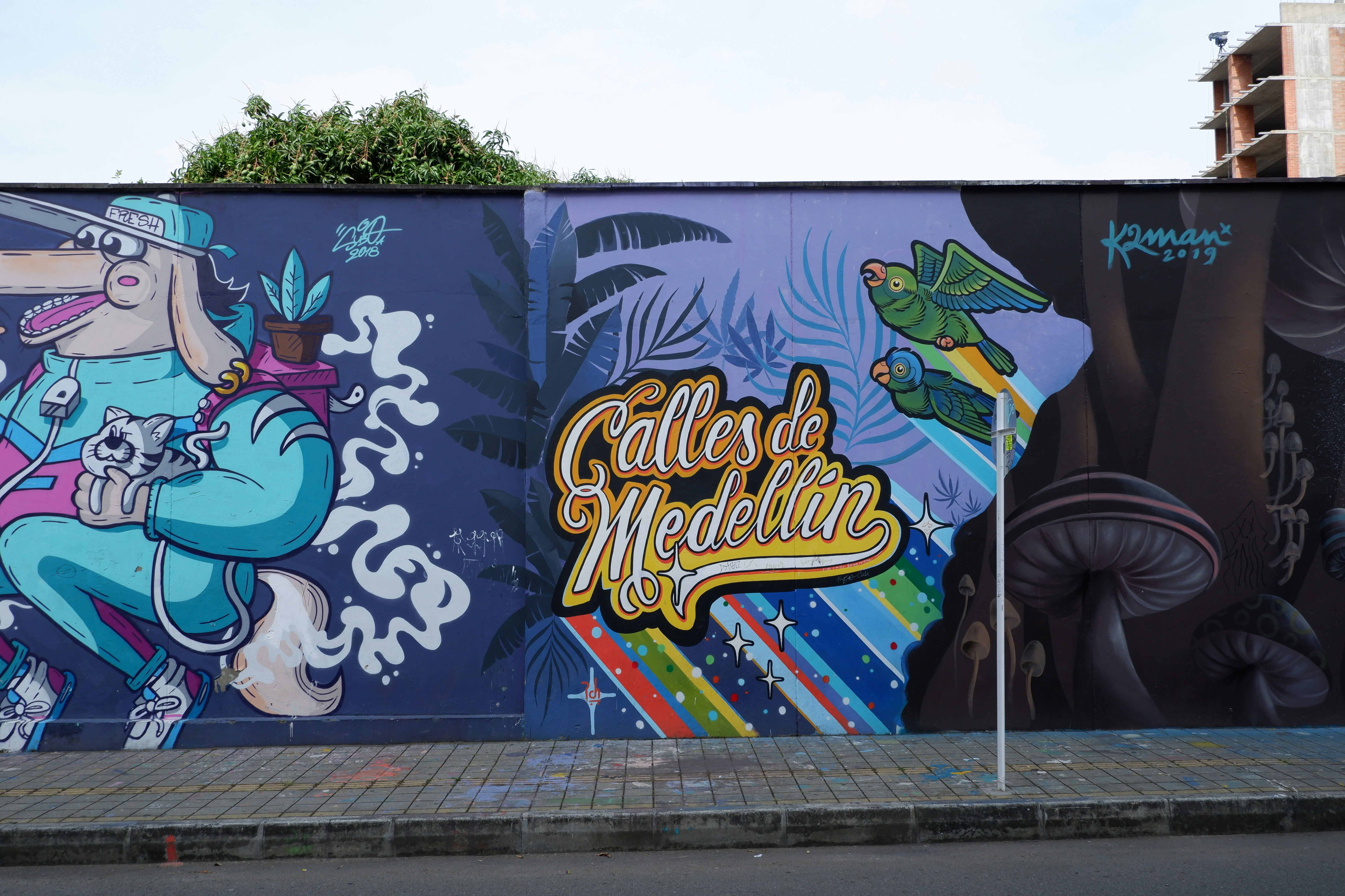 A wall along an El Poblado street is covered in colorful graffiti art  