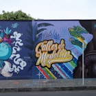 A wall along an El Poblado street is covered in colorful graffiti art  