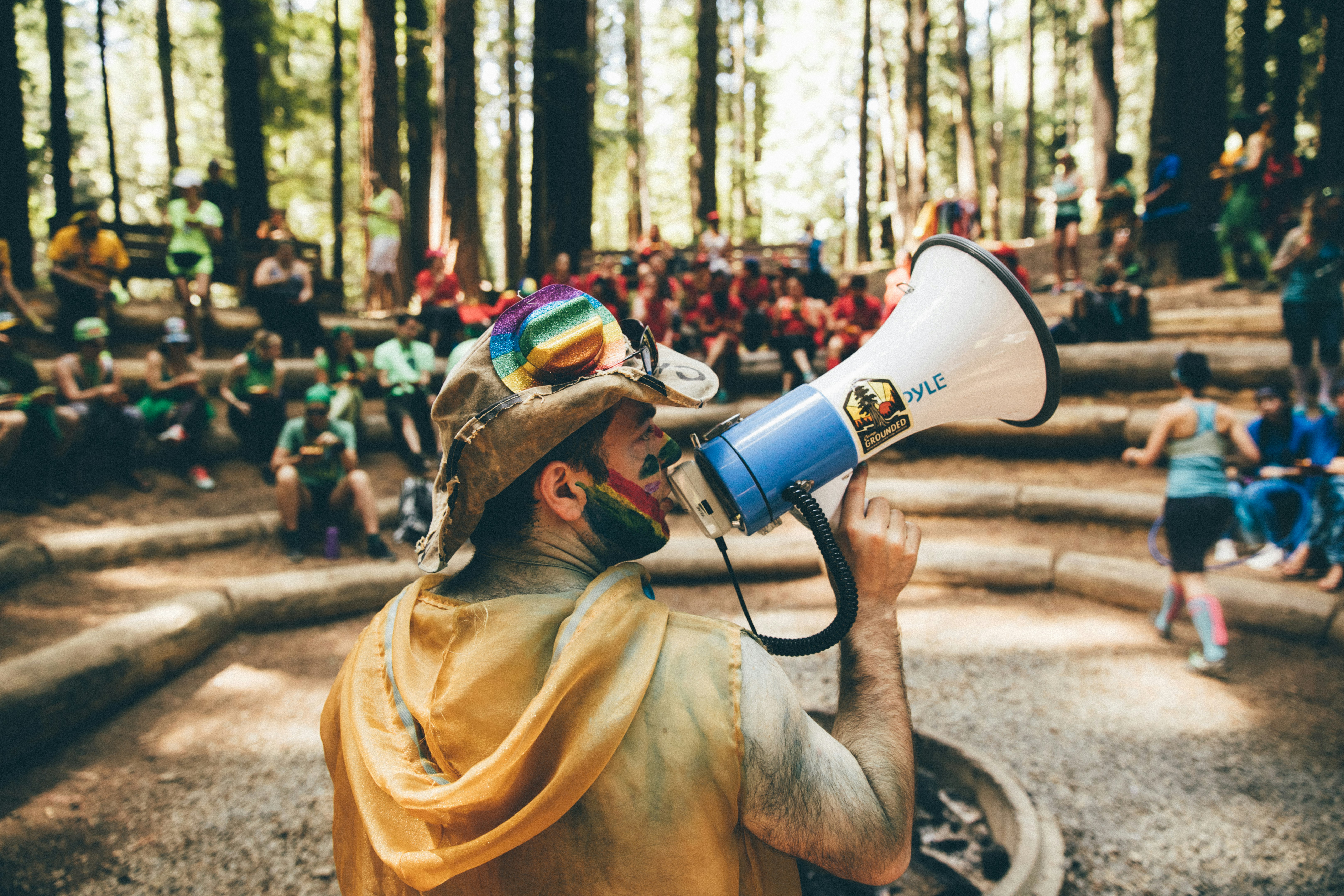 Guy in a rainbow hat holding a megaphone 
