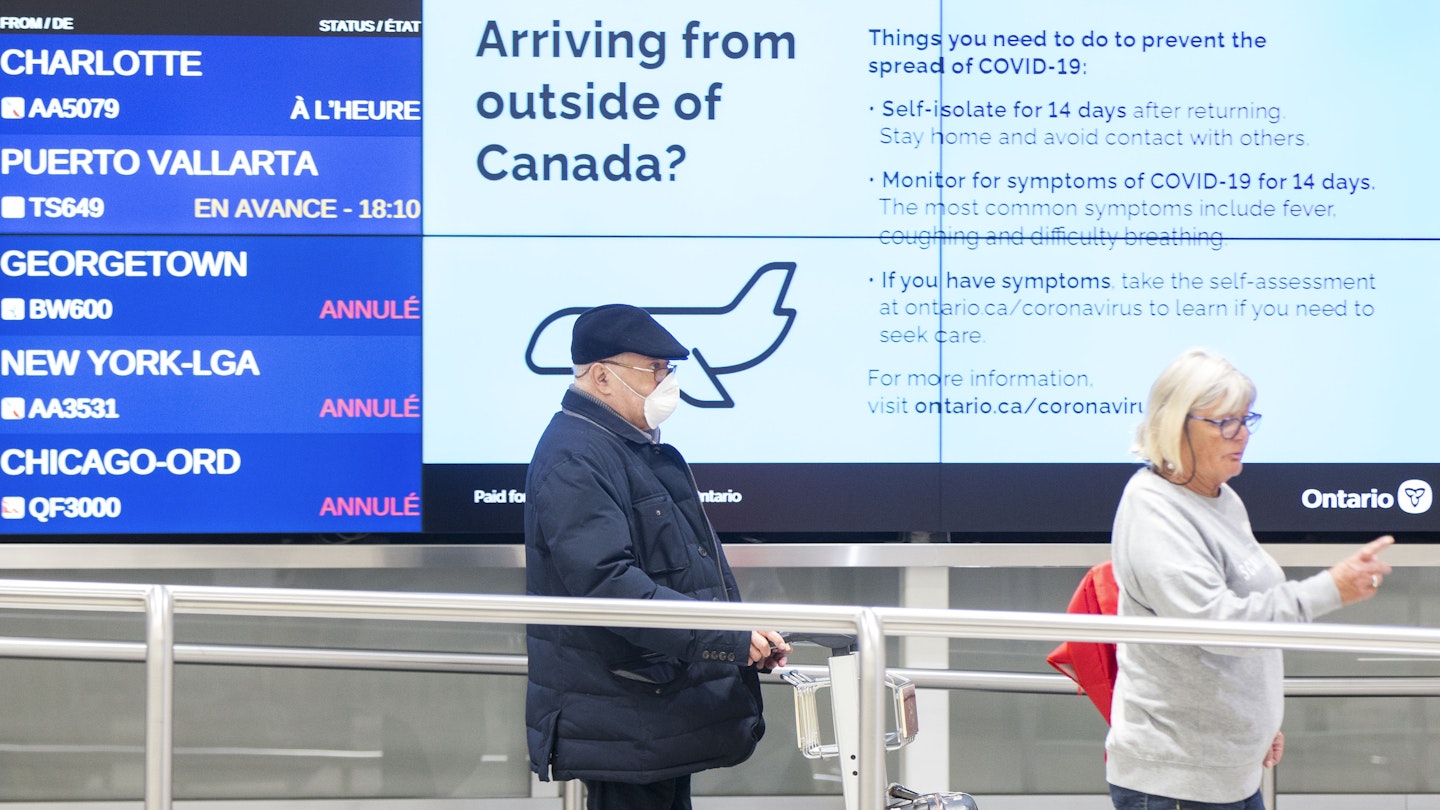 Travelers arrive at the Pearson International Airport in Toronto, Canada, on March 26, 2020. Canada imposed a 14-day mandatory self-isolation rule for any traveler returning to Canada. 