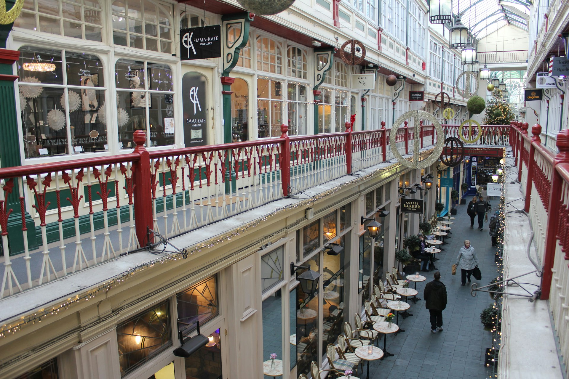 A view looking down on the narrow walkway that runs through the centre of Cardiff's Castle Arcade. The shopping arcade is more than 100 years old and is lined with small shops and businesses.