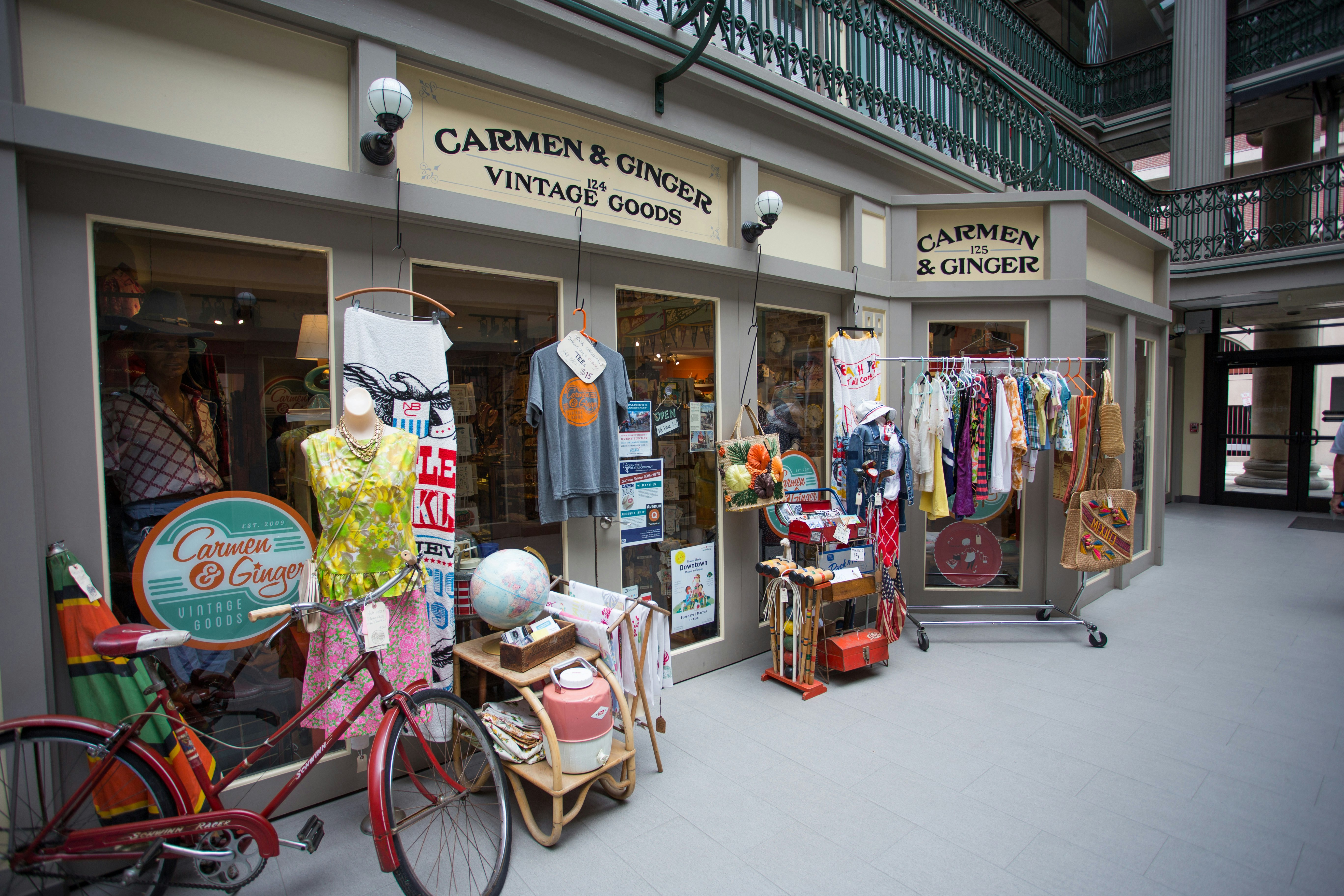 Facade of a vintage store with sign reading Carmen and Ginger and displays of dresses out front