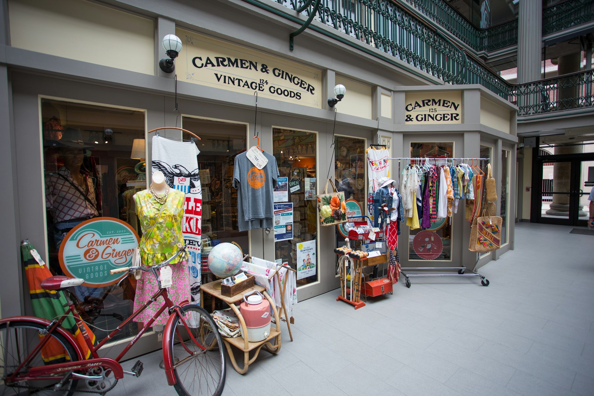 Facade of a vintage store with sign reading Carmen and Ginger and displays of dresses out front