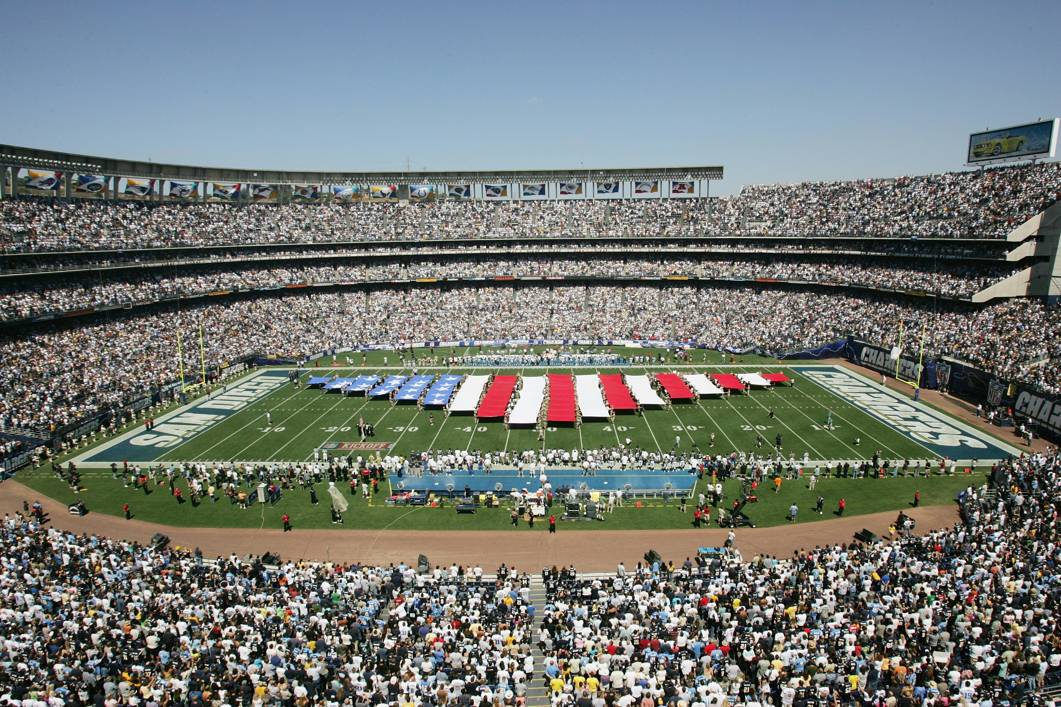 A stream making up the US flag is unfurled in the middle of the field at a packed Chargers stadium; nfl cities travel