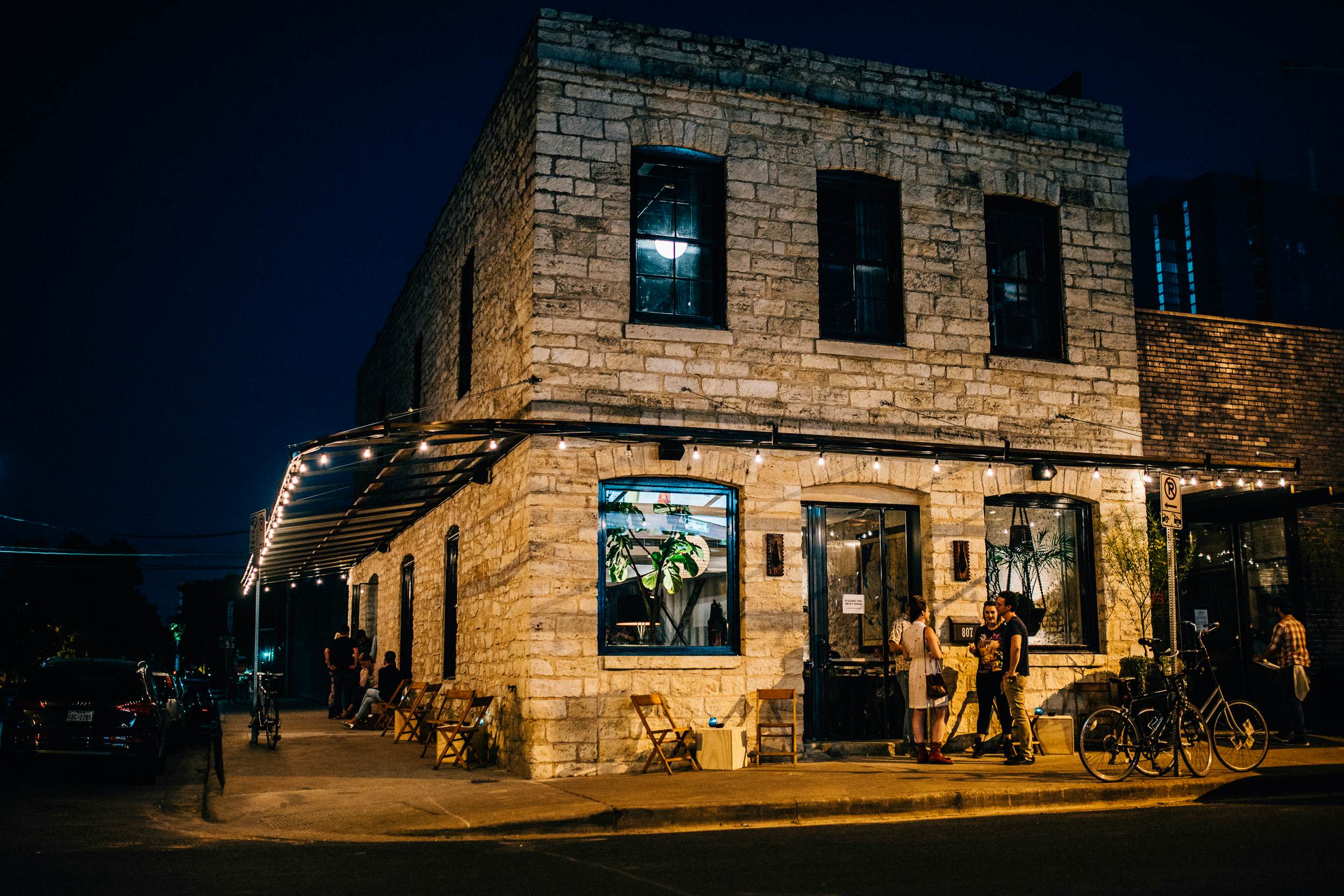 Brick exterior of a two story building lit up at night