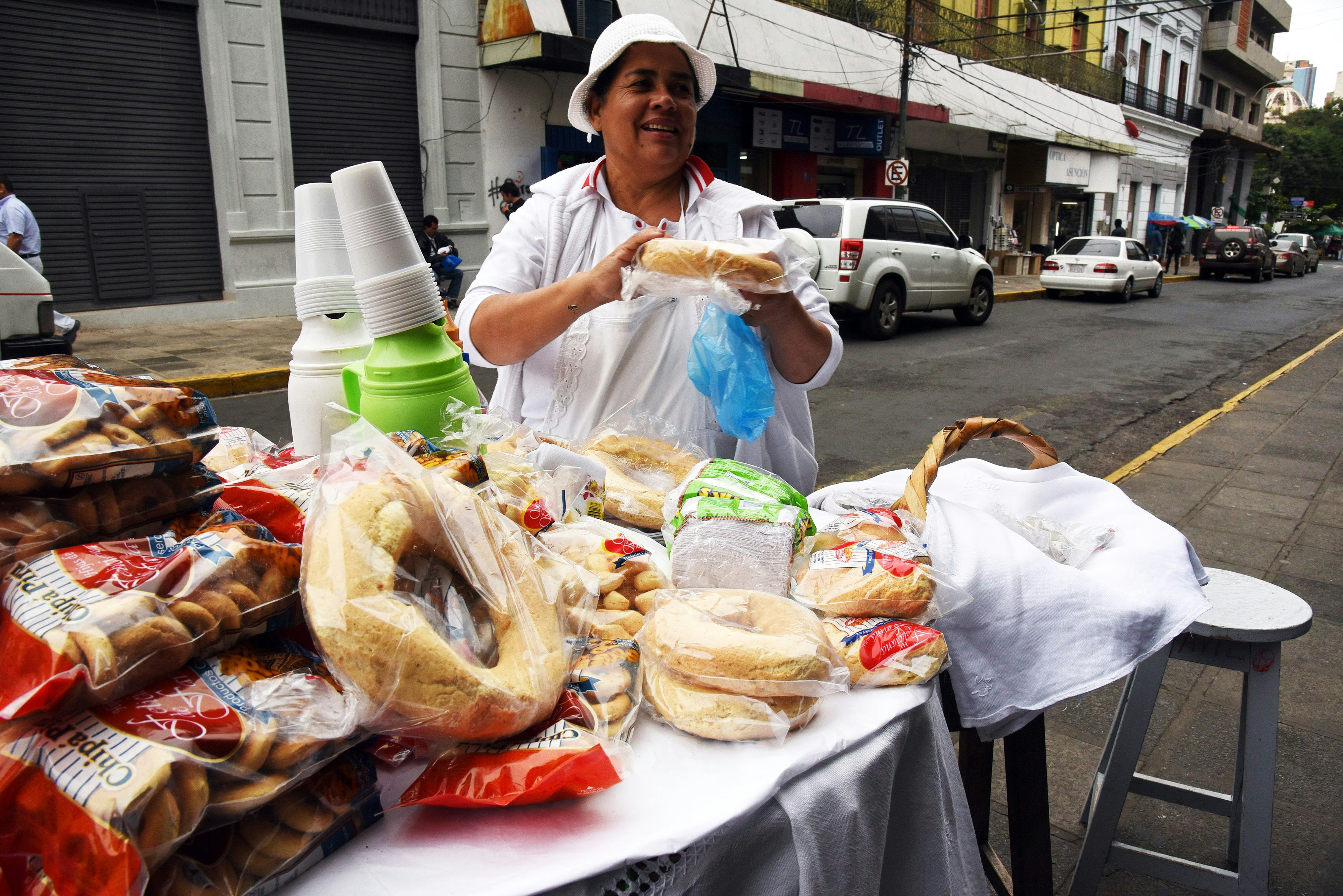 A street vendor holds a packaged chipa (cheese flavored rolls) in front of her stall in Asuncion, Paraguay