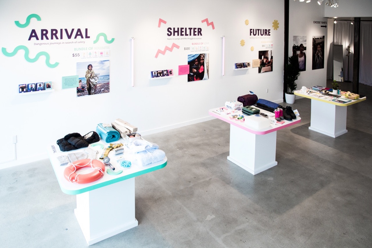 Merchandise displays at the Los Angeles Choose Love store, divided into sections for Arrival, Shelter, and Future needs