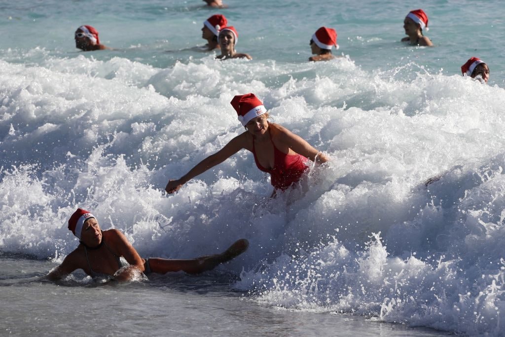 People dressed as Santa Claus take part in a traditional Christmas swim