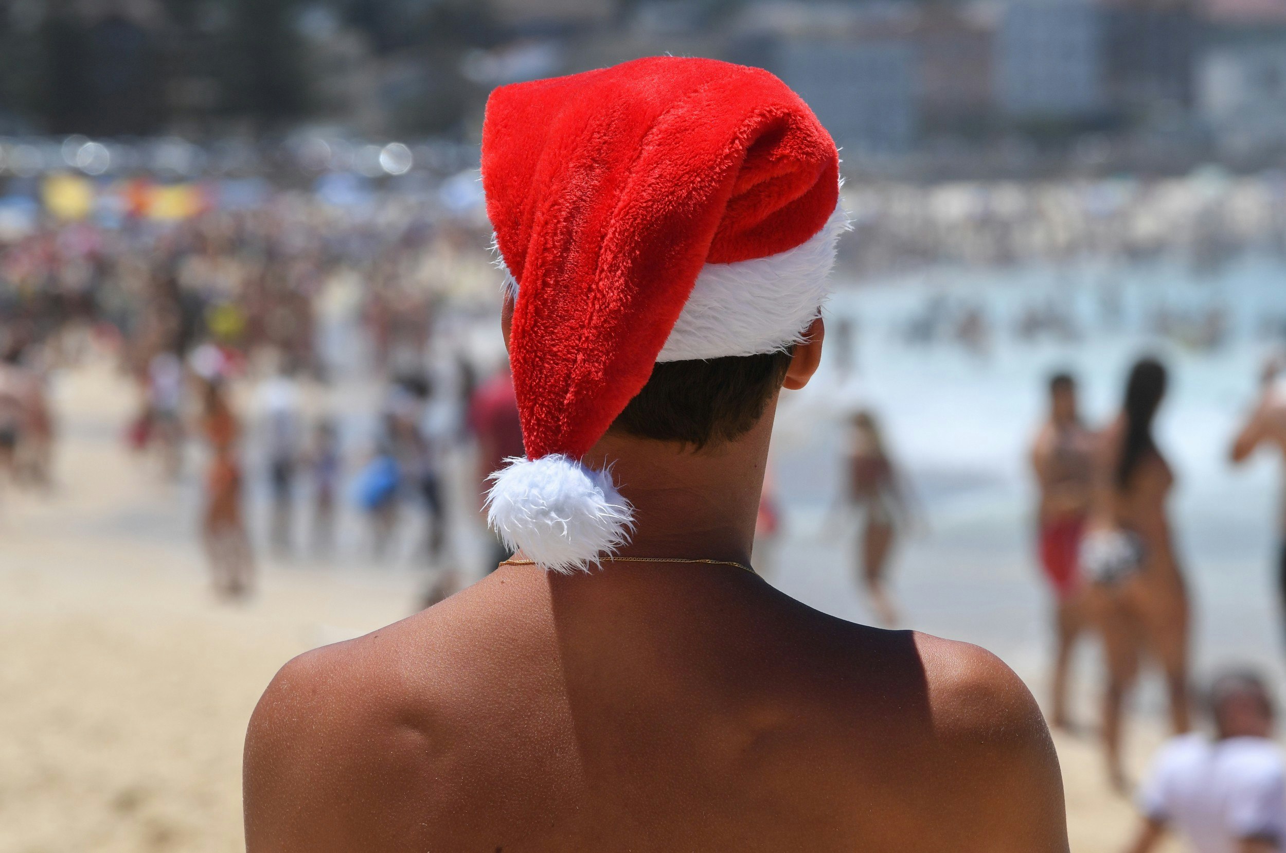  A man wearing a Santa hat on a beach