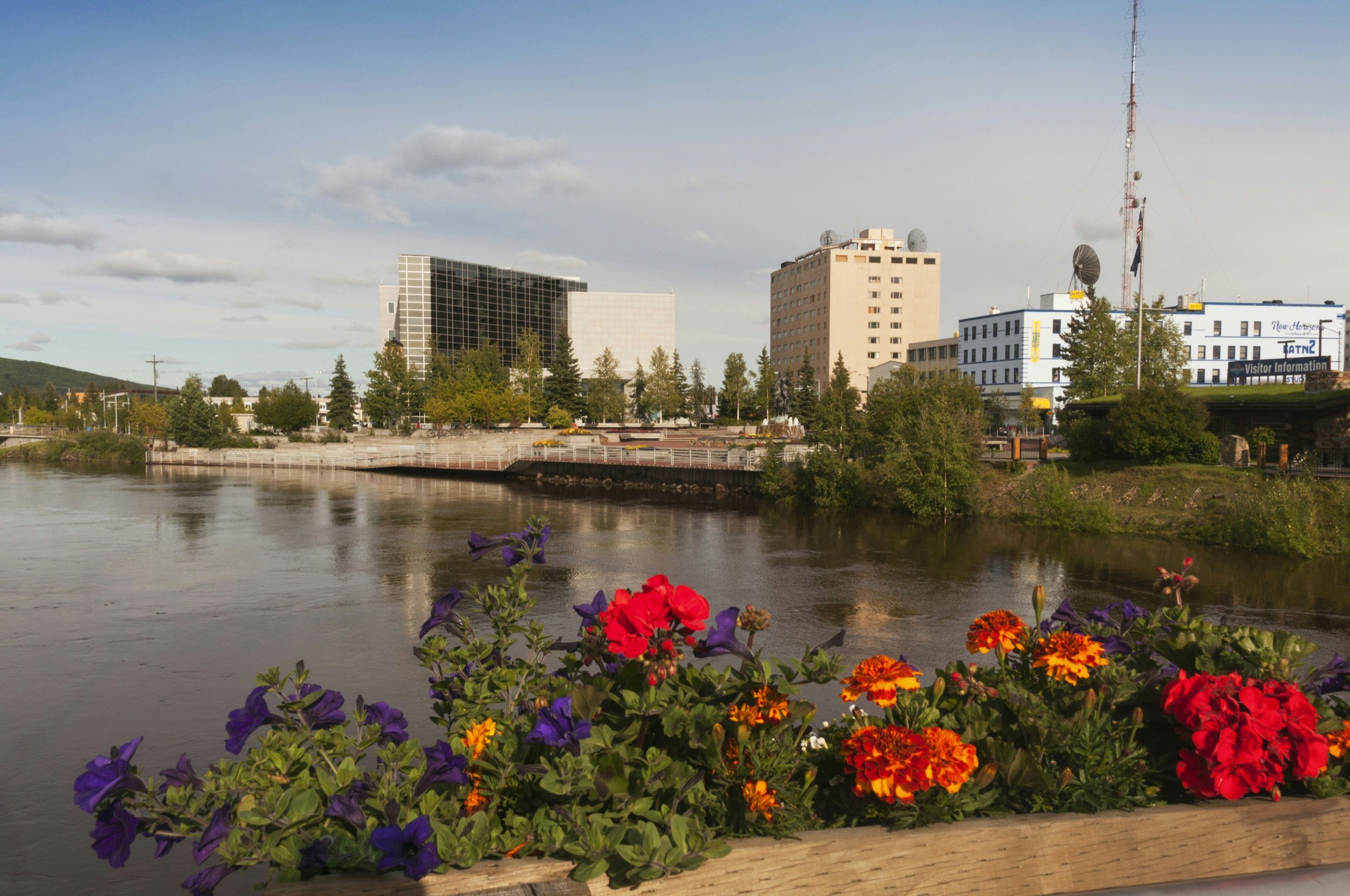 Flowers sit in front of a building and a pond in Fairbanks, Alaska