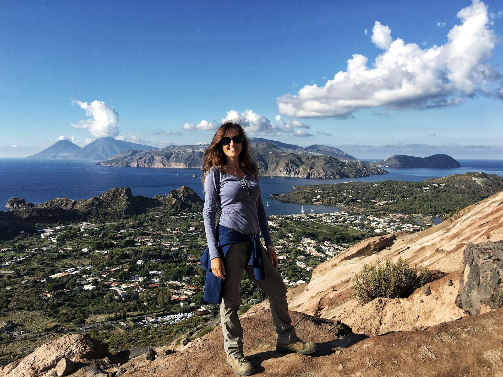 Claudia poses on a hill top high above a town in South America.