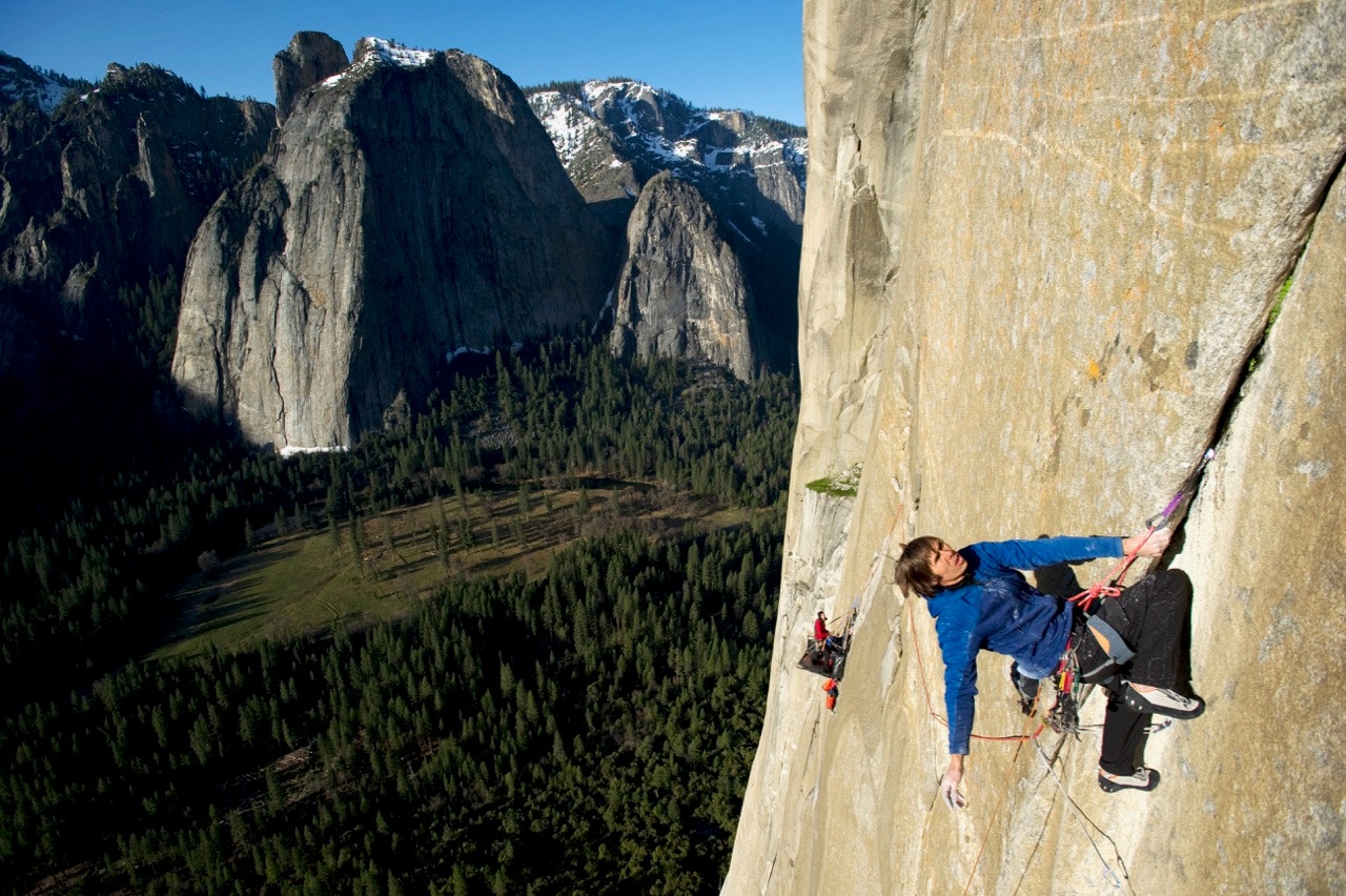 One man climbs El Cap while his climbing partner belays from a portaledge in Yosemite National Park, California.