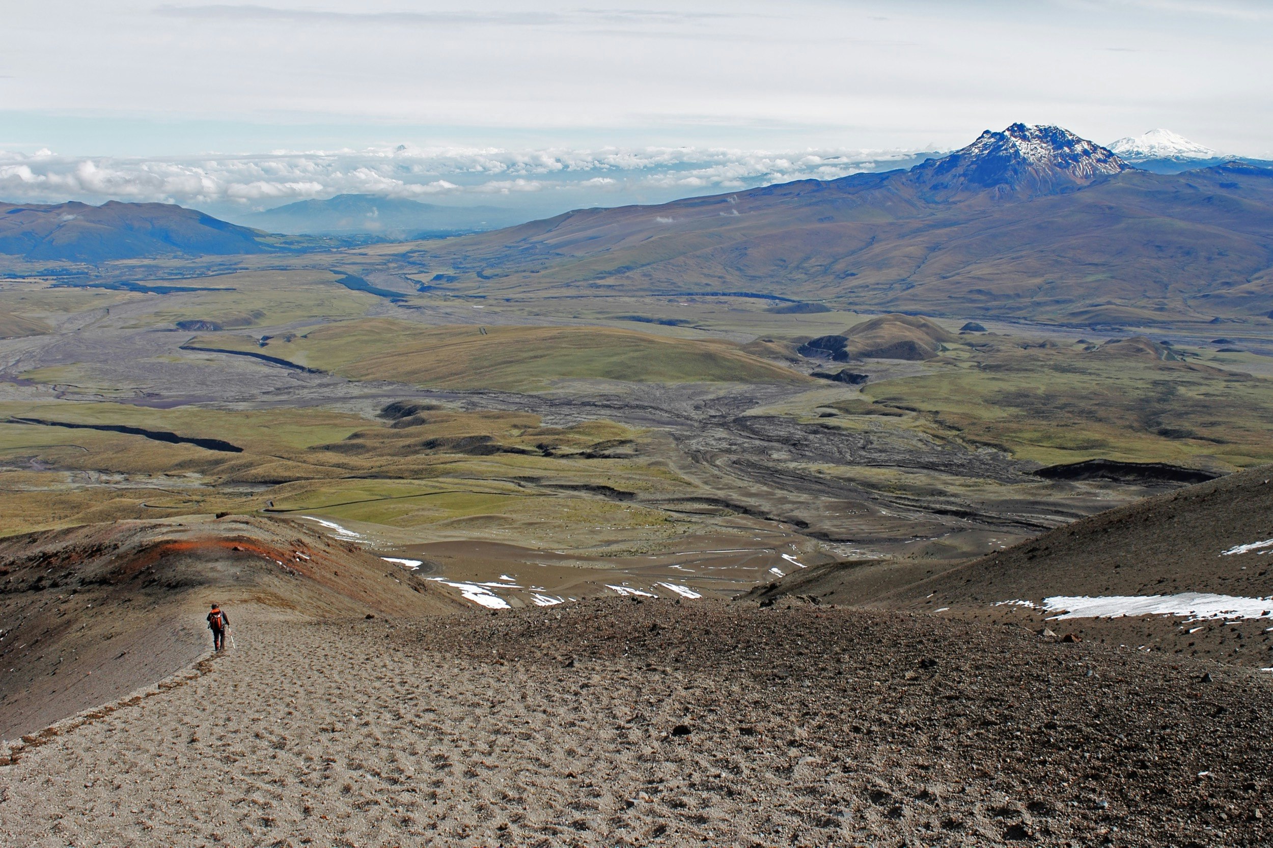 A solitary backpacker walks through scrubland on his or her way to an isolated mountain in Ecuador; Climbing a fourteener