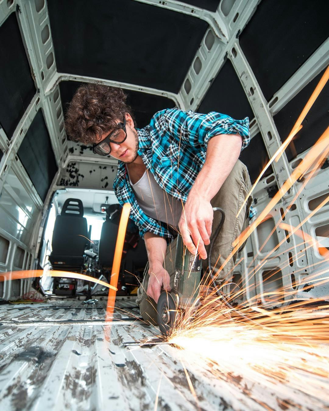 sebastian working on his van with an angle grinder