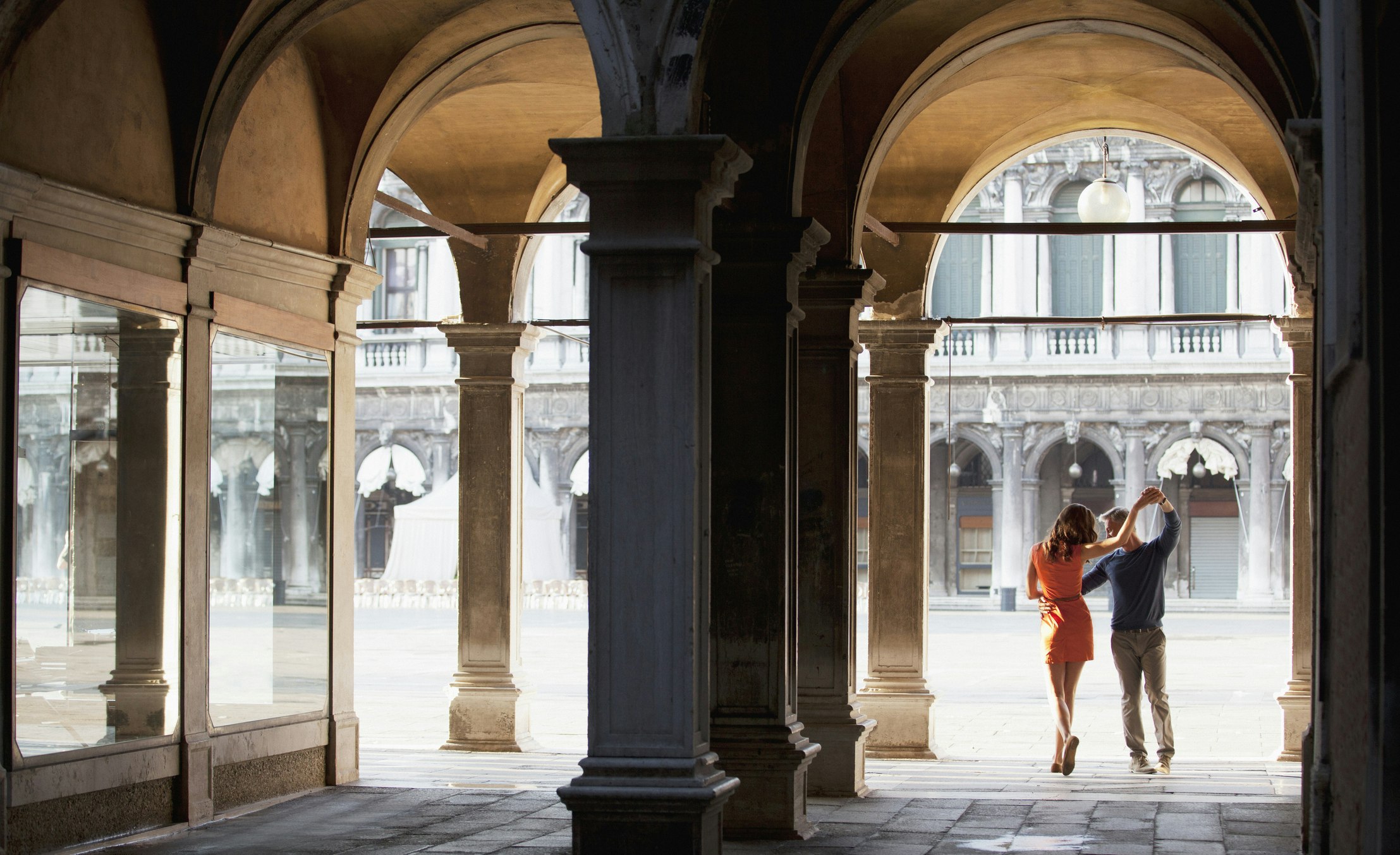 A couple dances in an archway in Venice
