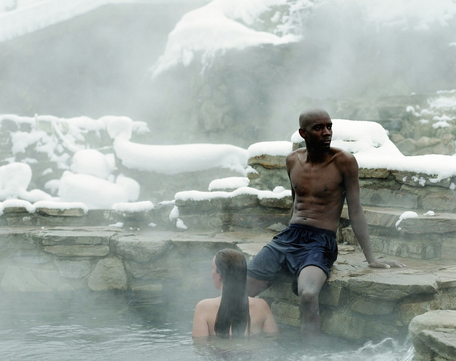 A man and a woman soak in a hot spring in Steamboat, Colorado