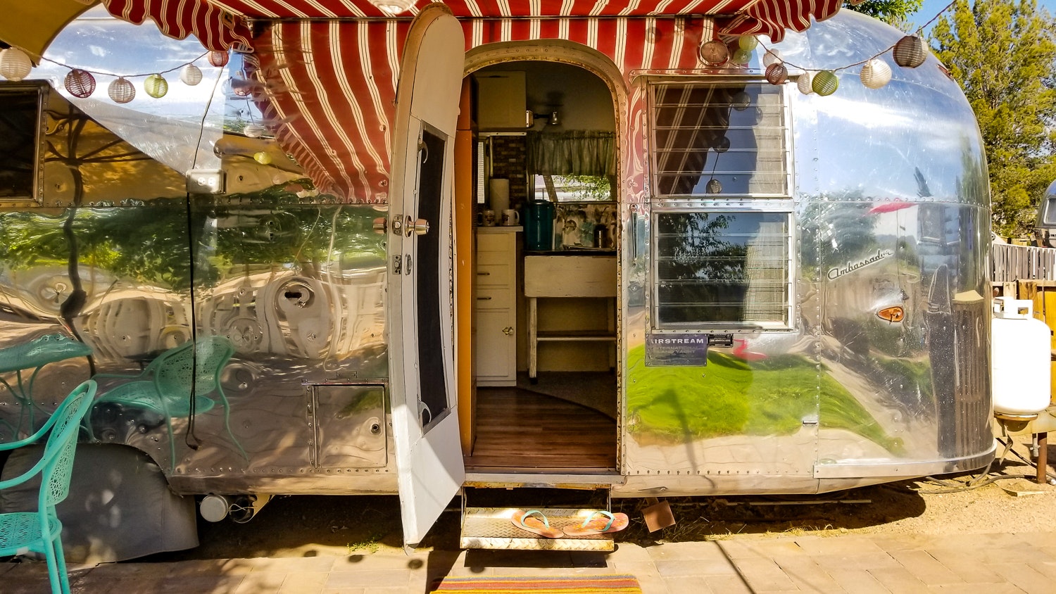 The open door of a chrome Airstream trailer