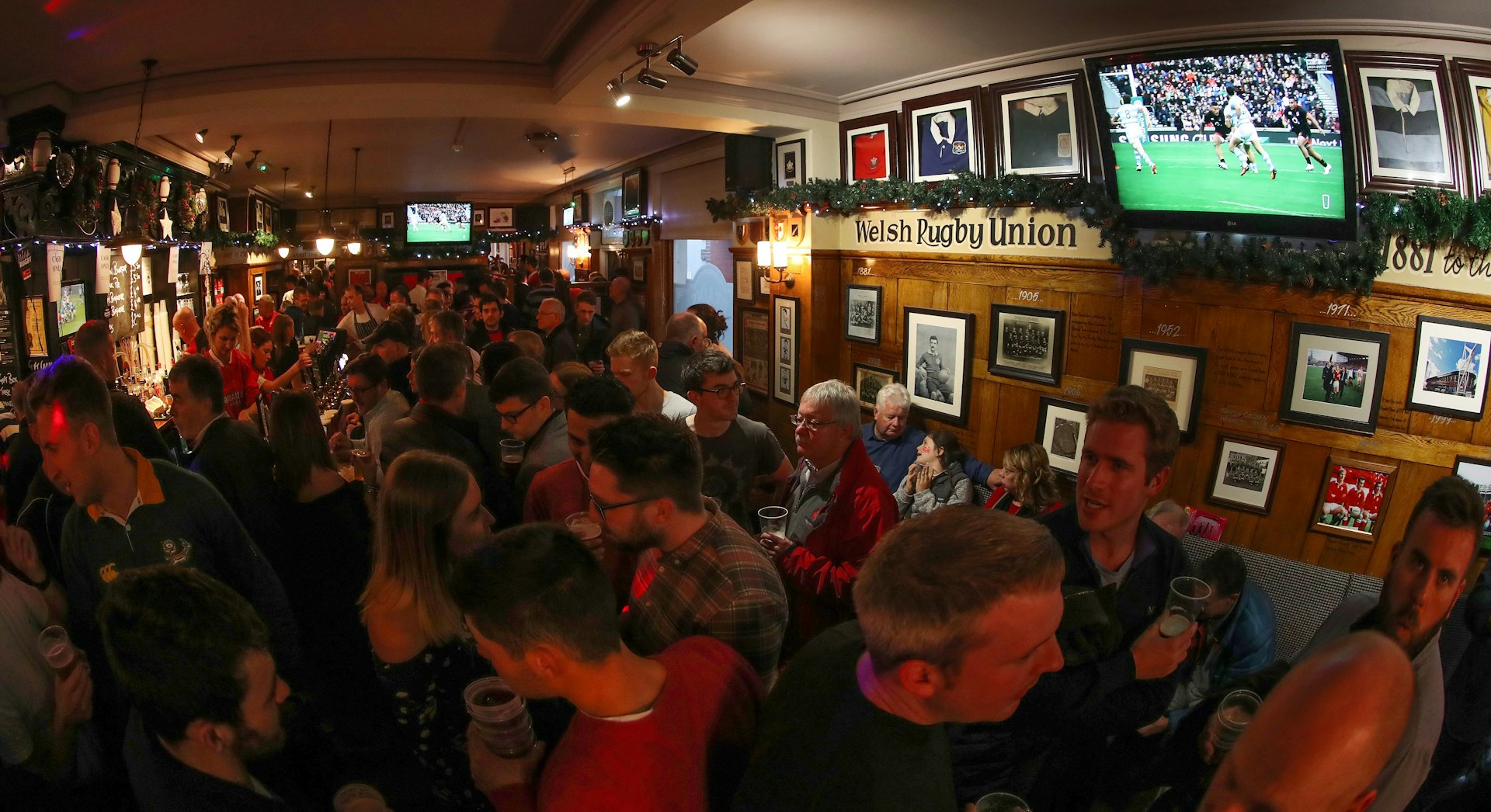 A view of the interior of Cardiff's City Arms pubs ahead of a rugby match in the city. The pub is pack full of people, most sporting red Wales rugby jerseys.