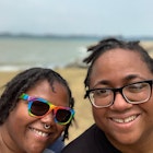 A pair of women smile on Singapore beach  