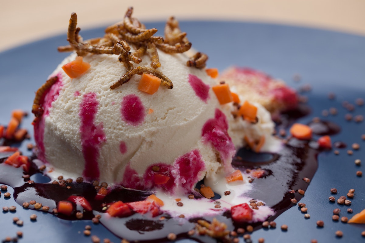 Kolamjölmaskar över vaniljglass toppad med rostad sötpotatis och amarantfrön