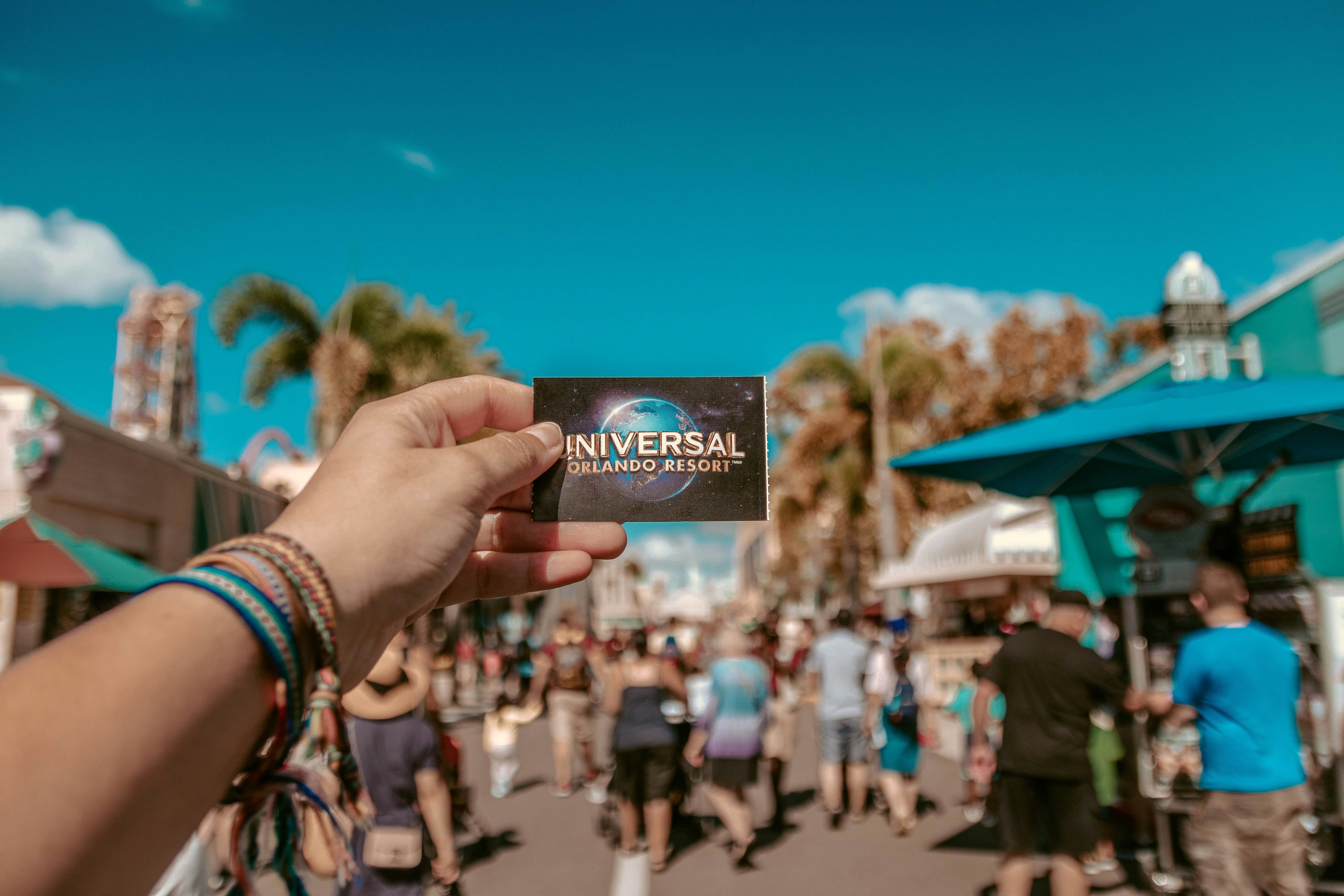 Person holding Universal entrance card at theme park gates