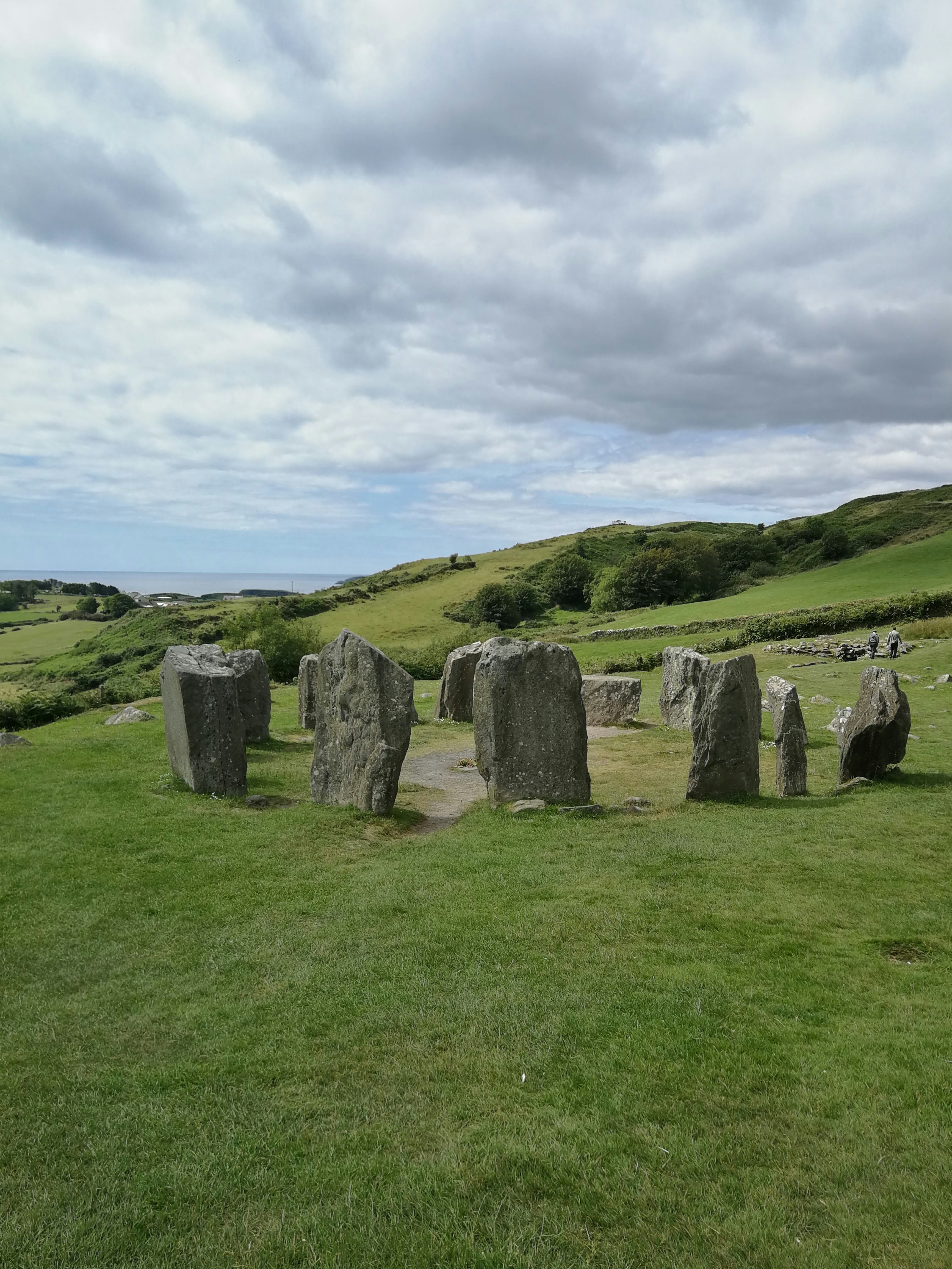 Standing on a grassy hill, with the sea just visible in the distance, is a collection of ancient standing stones, arranged in a circle.