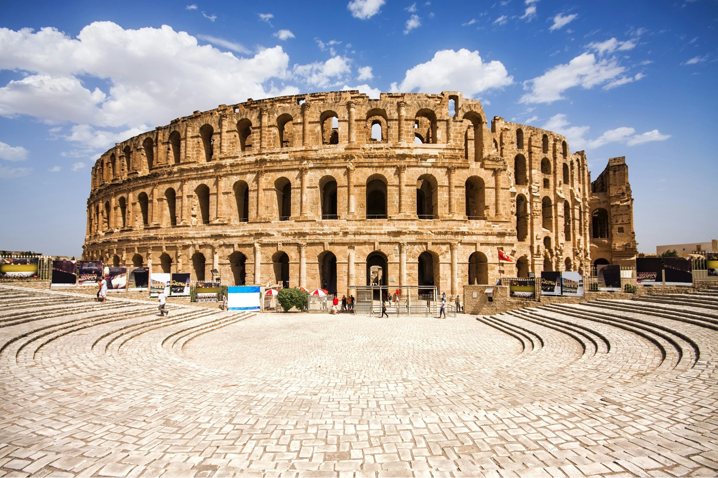 An image looking across a cobbled pavilion, with what looks like Rome's Colosseum rising in the background; El Jem's colosseum is very similar looking to Rome's, and only slightly smaller.