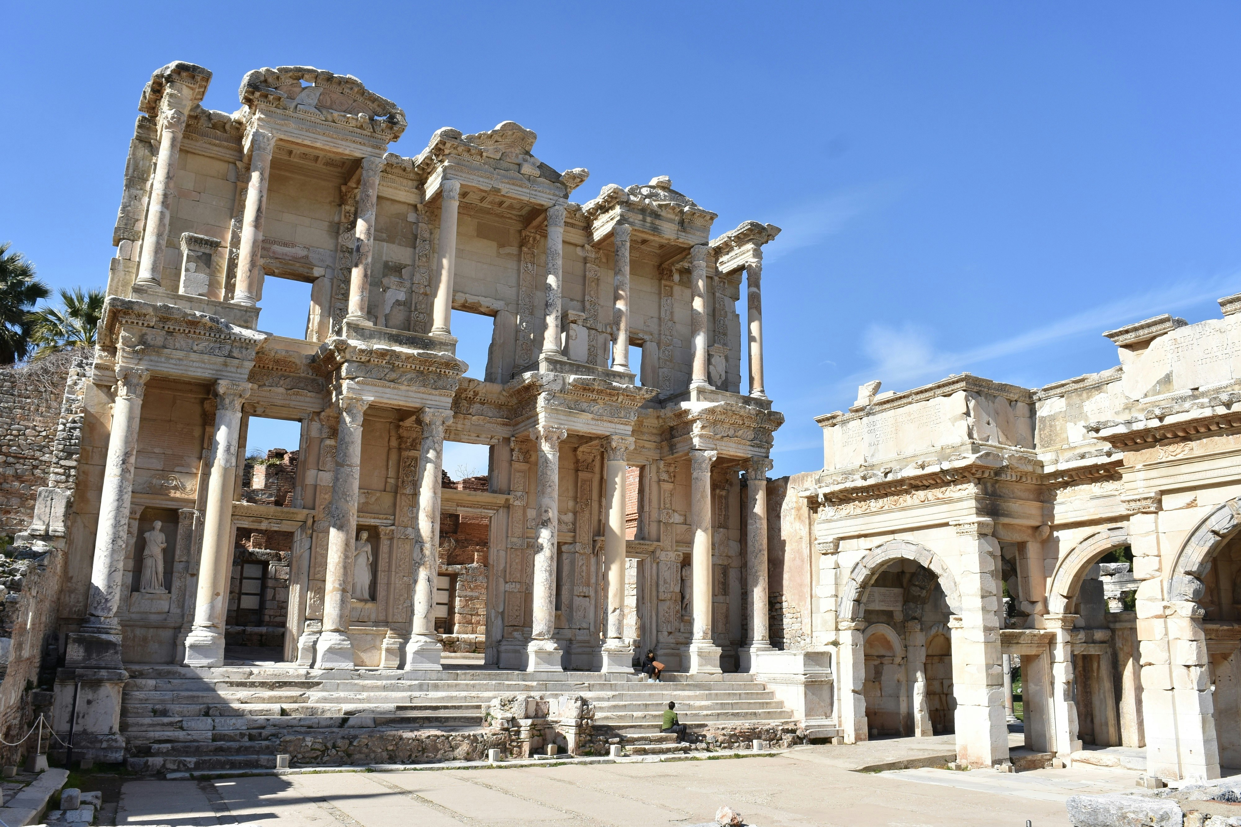 Ruins outdoors in Ephesus, Turkey, on a sunny day. Clear skies are visible in the background. 