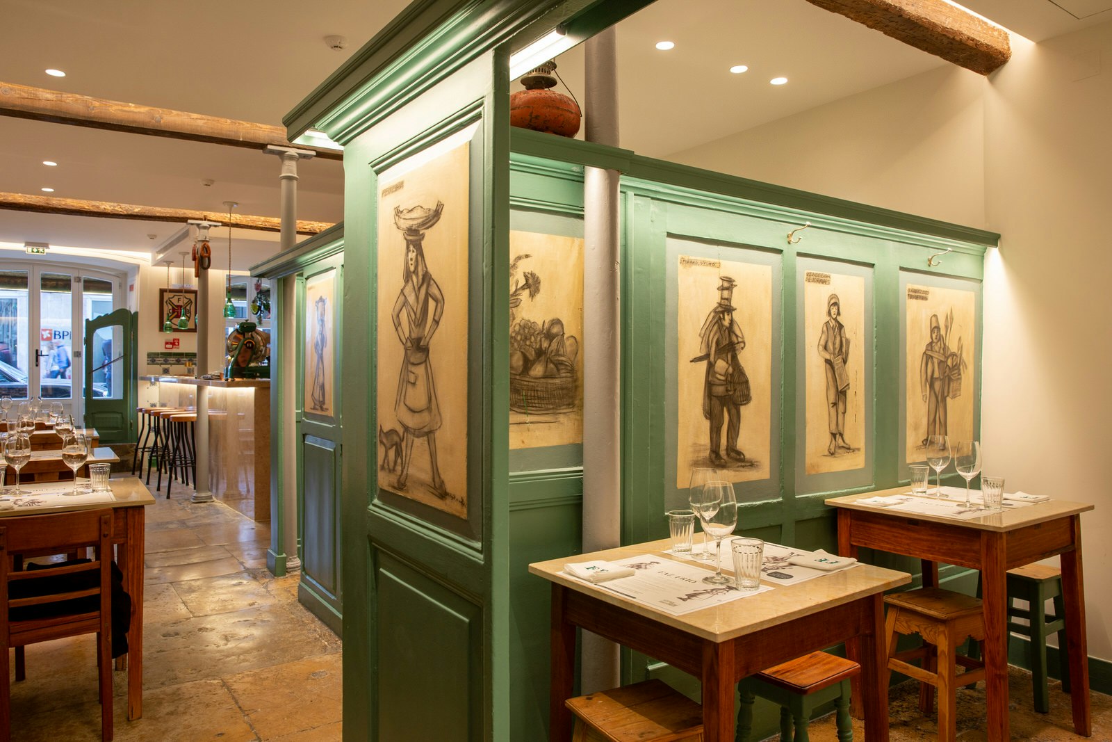 Faz Frio restaurant's interior with sage green walls and ink portraits, Lisbon.