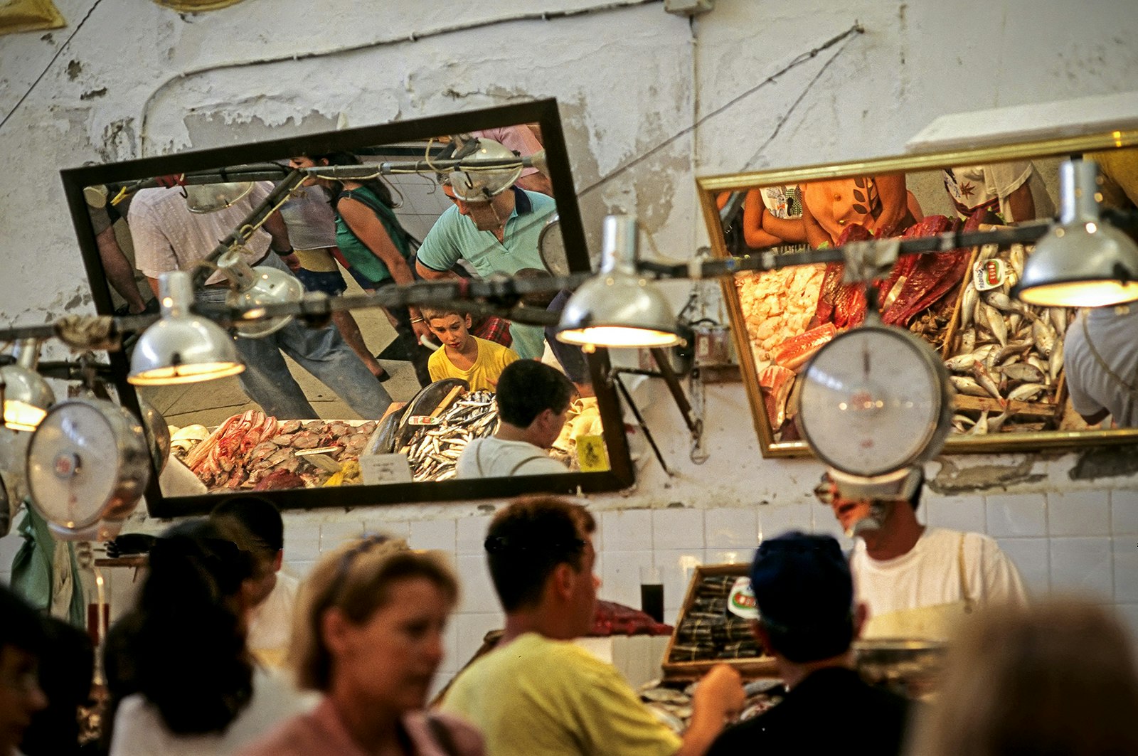 Mirrors are suspended over tables of seafood at a local market in Sanlúcar de Barrameda, revealing all kinds of fish for sale. Cádiz, Spain.