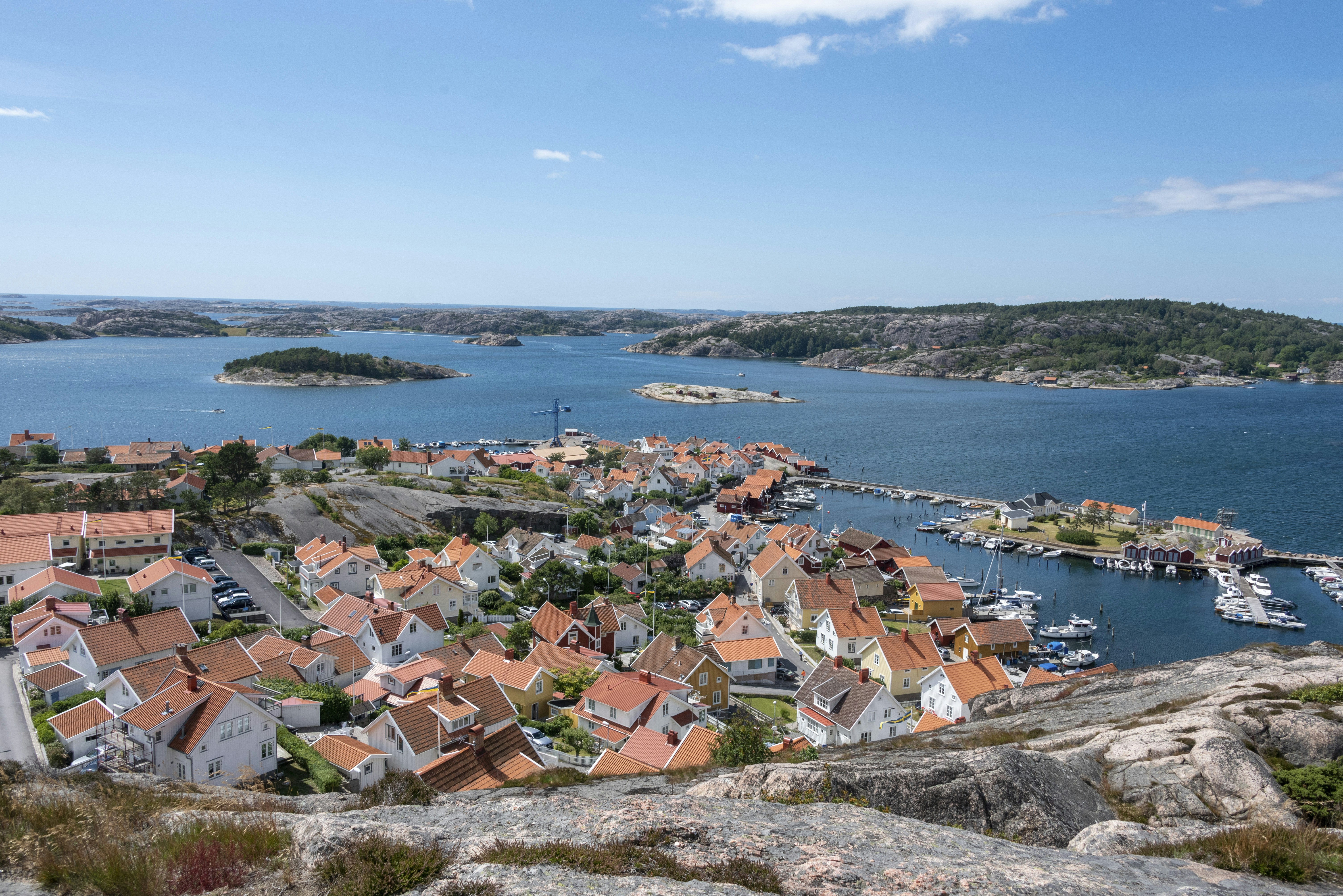 Fjällbacka, Sweden, a more relaxed stag or hen experience. The coast is visible, and a cluster of houses painted white with red roofs are in front.