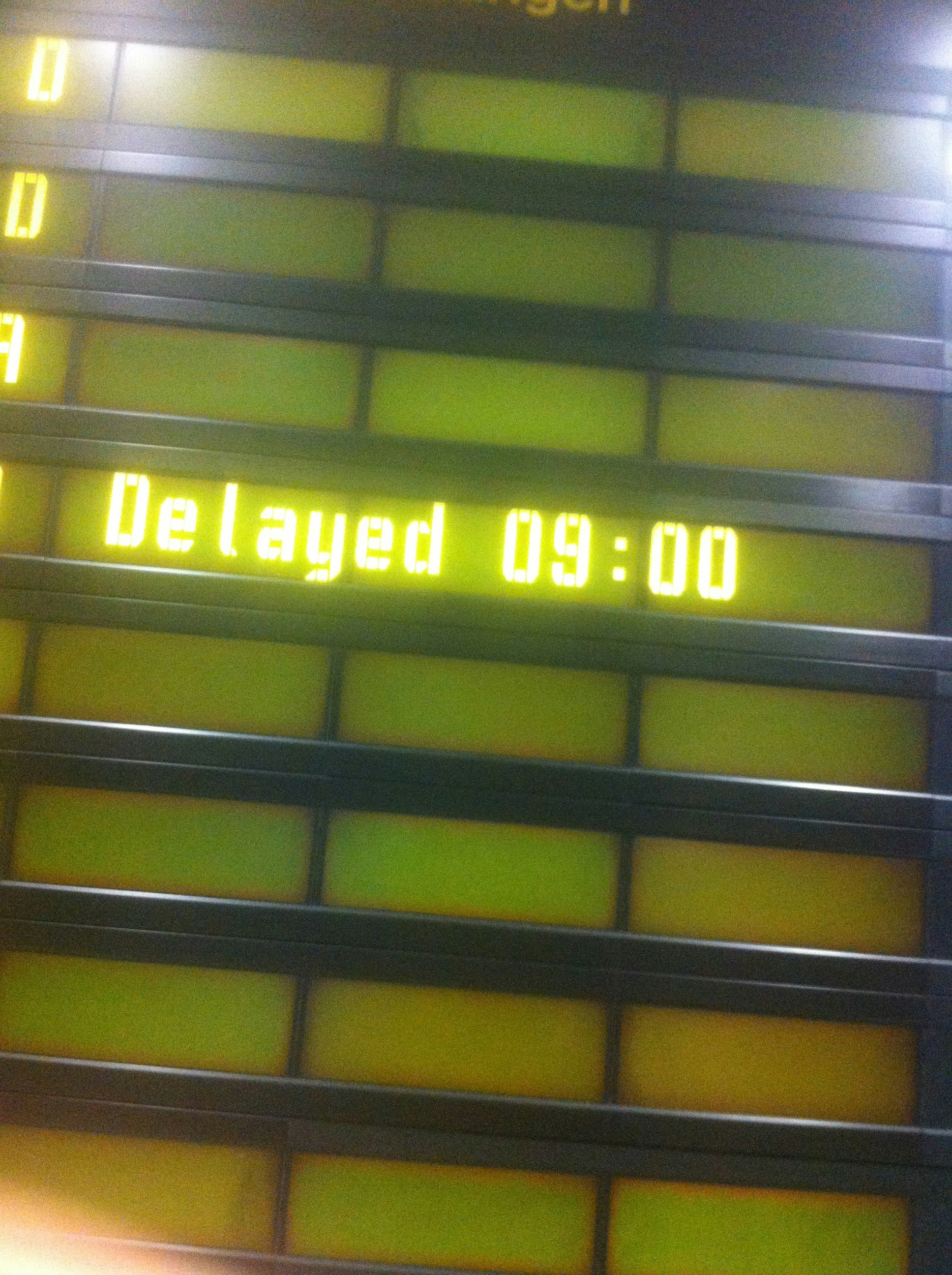 A screen reads 'Delayed: 9.00', referring to either a plane or a train
